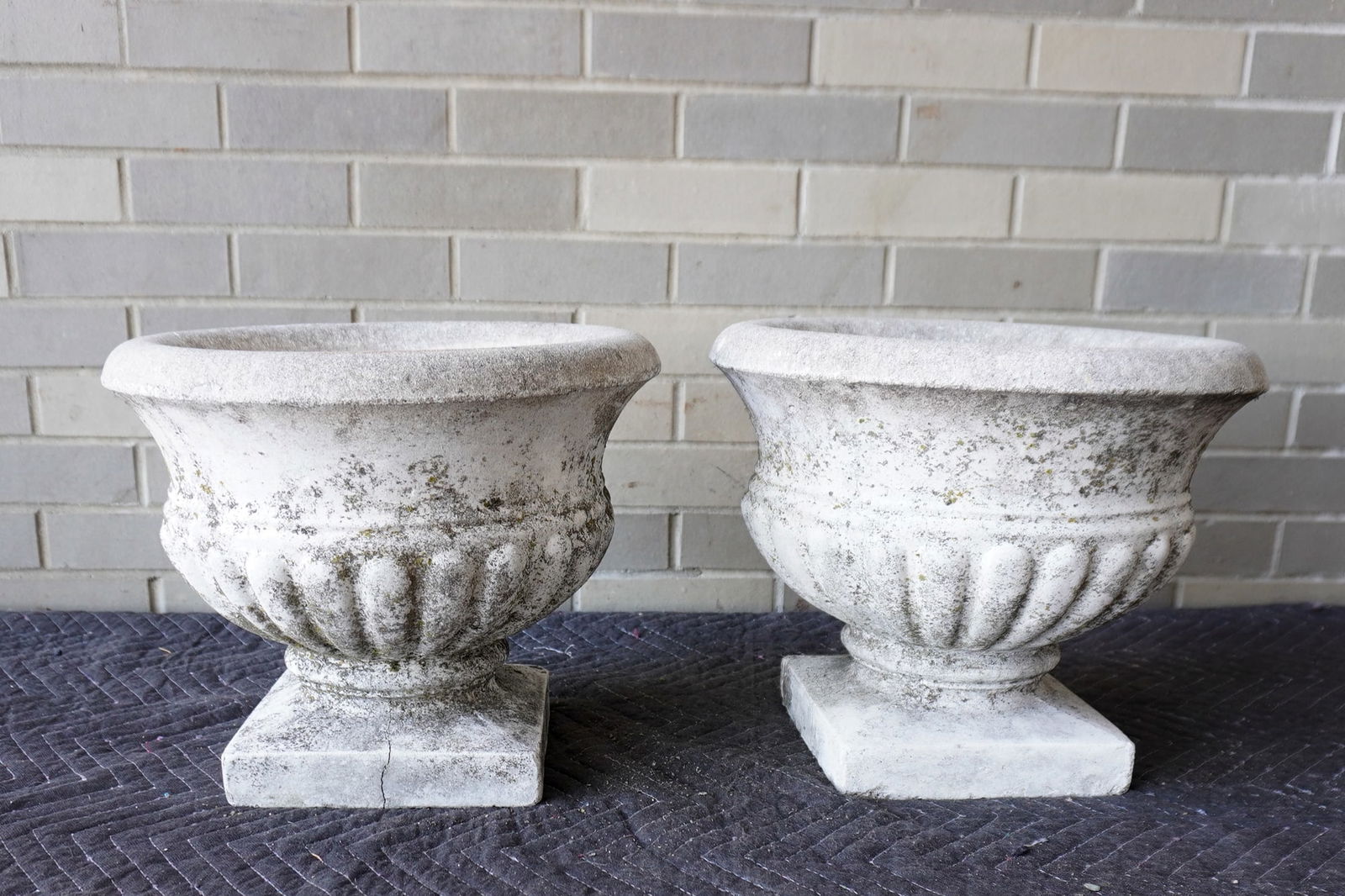 Two matching concrete garden urns in old weathered white paint, mid to late 20th century - both with: Two matching concrete garden urns in old weathered white paint, mid to late 20th century - both with tight hairlines on base and with small chip, else structurally sound and in good condition. Measure