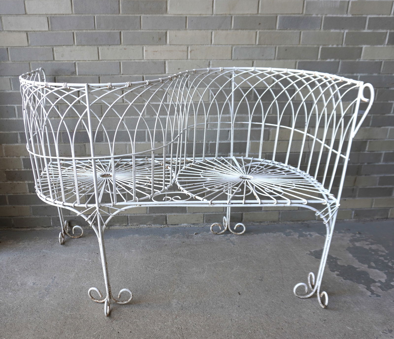 A wire tete-a-tete in very good condition, mid to late 20th century. Measures 48"W x 30"D x 34: A wire tete-a-tete in very good condition, mid to late 20th century. Measures 48"W x 30"D x 34 1/4"H.
