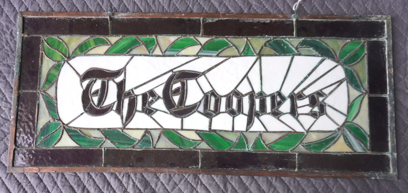 A leaded and stained glass window with the central panel having the family name "THE COOPERS": A leaded and stained glass window with the central panel having the family name "THE COOPERS" surrounded by a leaf border, circa 1950-70. Very good condition. Measures 27"W x 12"D.