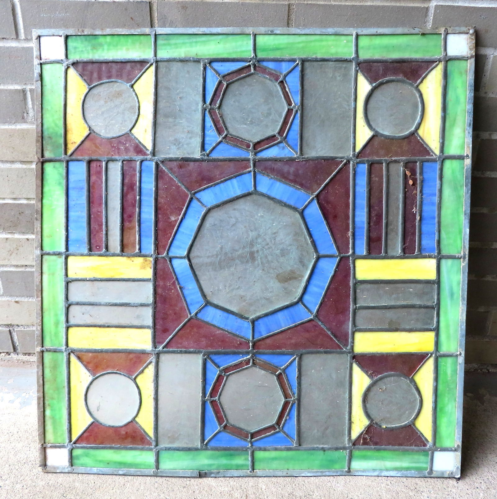 A leaded and stained glass window in the style of Frank Lloyd Wright, circa 1950. One small break in: A leaded and stained glass window in the style of Frank Lloyd Wright, circa 1950. One small break in the lead edge frame, else very good condition. Measures 26 7/8" x 28".