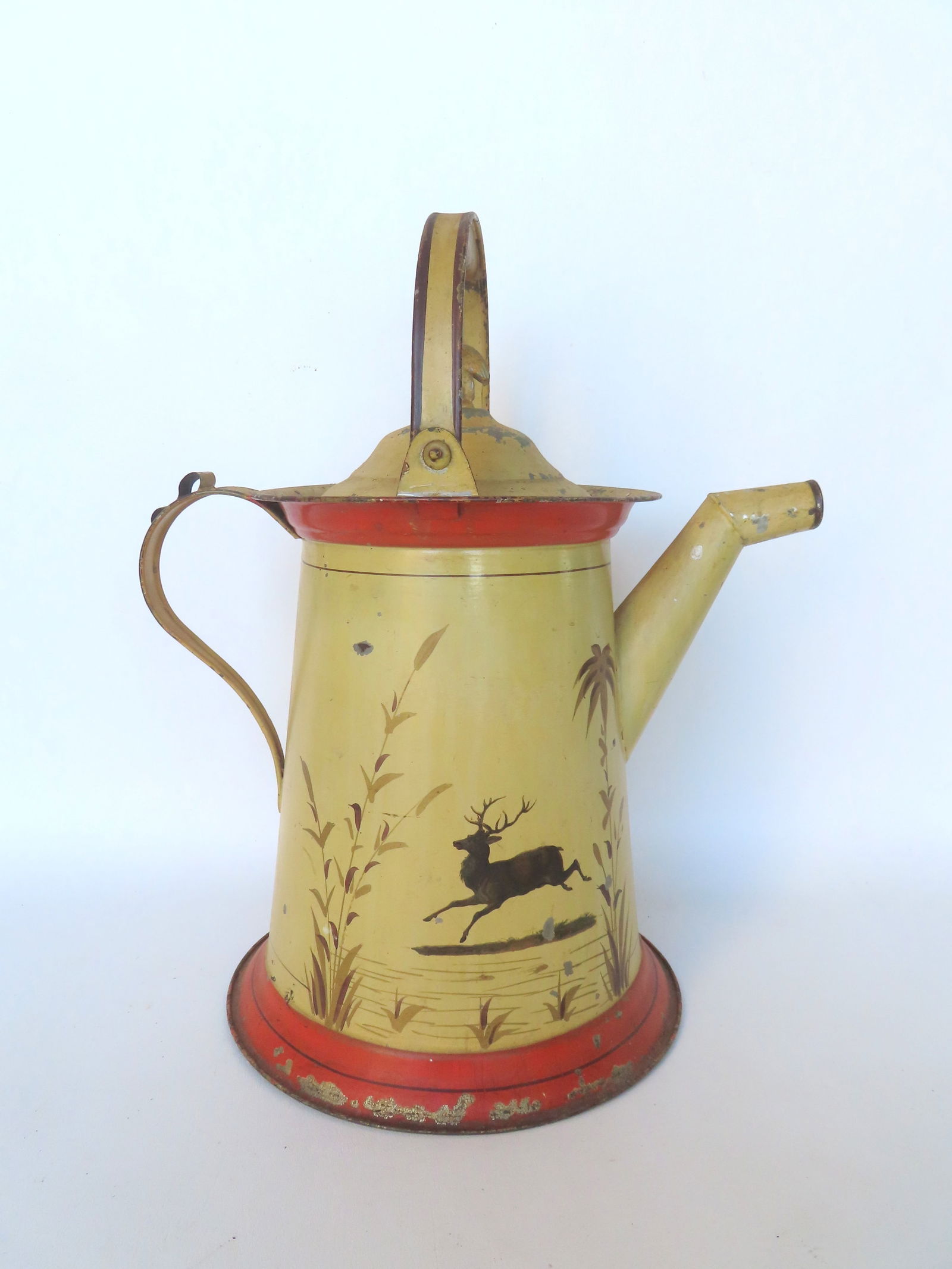 A 19th century watering can, having a lid with a spread wing eagle finial, swivel loop handle, in: A 19th century watering can, having a lid with a spread wing eagle finial, swivel loop handle, in original paint decorated by hand with leaping stags and flowers. The base with original paper label ma