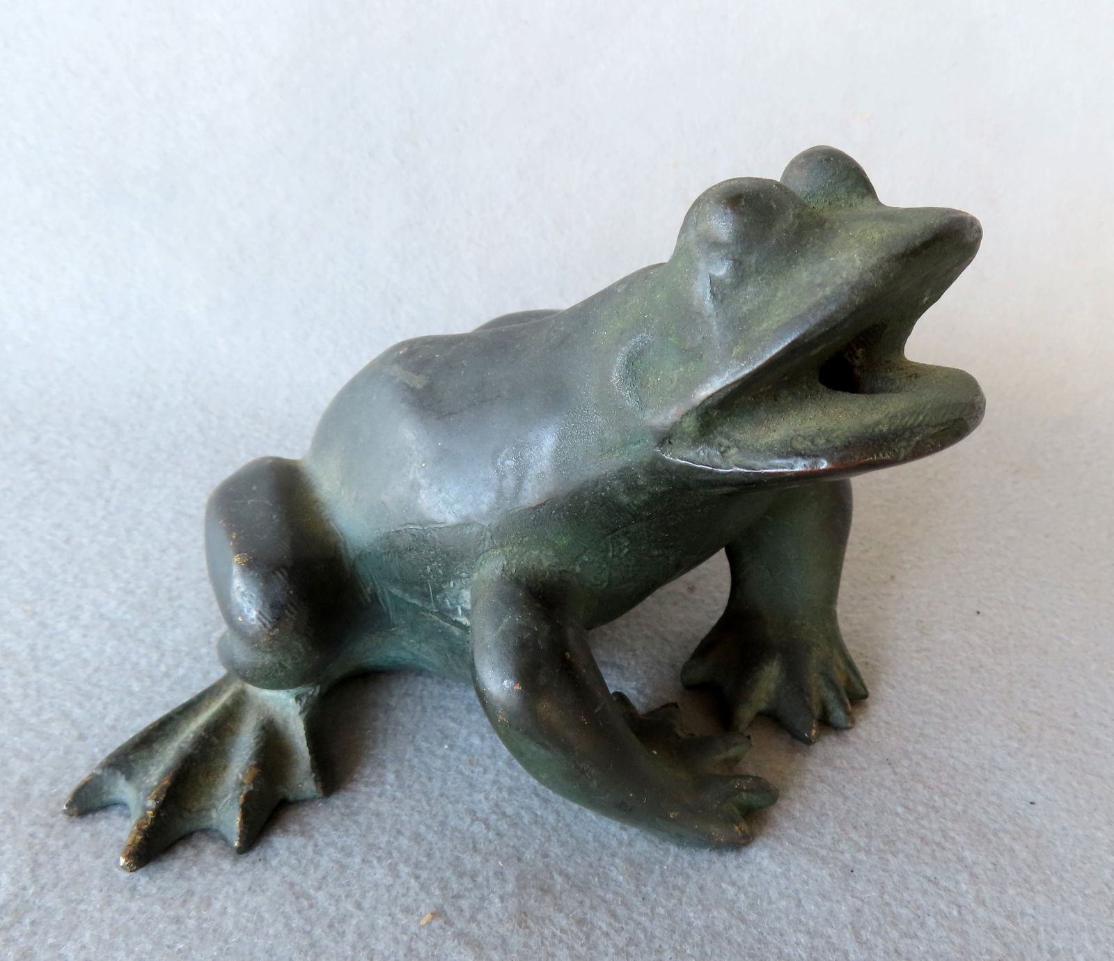 A small figural patinated bronze water fountain in the form of a life size seated bullfrog, early: A small figural patinated bronze water fountain in the form of a life size seated bullfrog, early 20th century. Very good condition. Measures 4 3/4"L x 6 1/2"W x 4"H.