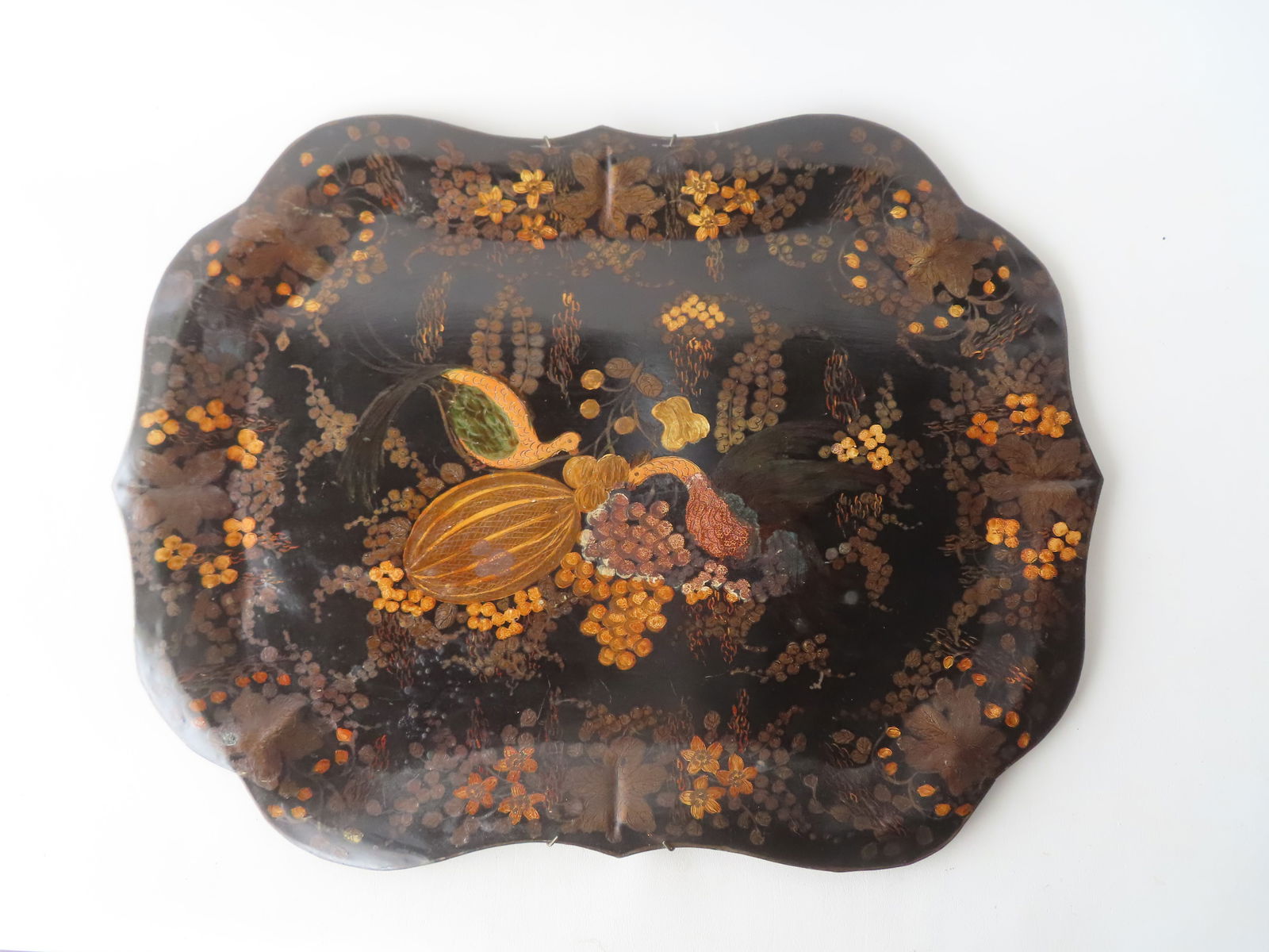 A very fine hand painted toleware tray having a scalloped edge painted with flowers and berries on: A very fine hand painted toleware tray having a scalloped edge painted with flowers and berries on vine surrounding the central image of 2 exotic birds feeding on grapes, fruit and watermelon. Origina