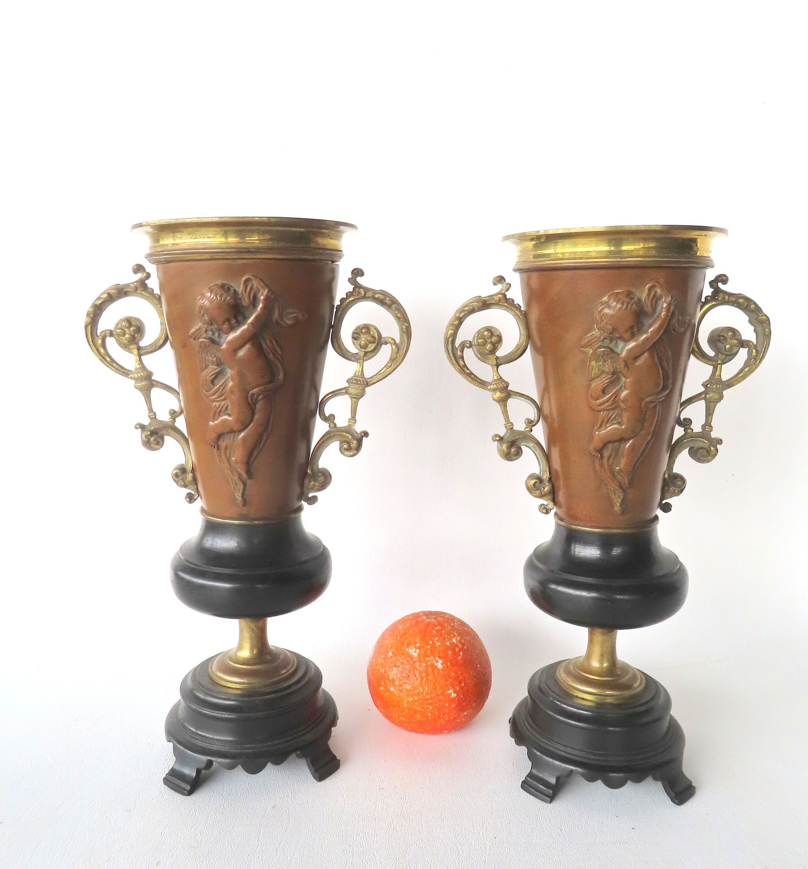 Pair of French bronze vases decorated with cherubs and having fancy scrolled bronze handles and: Pair of French bronze vases decorated with cherubs and having fancy scrolled bronze handles and mounted on black bronze footed stepped base, mid to late 19th century. Both in very good condition witho