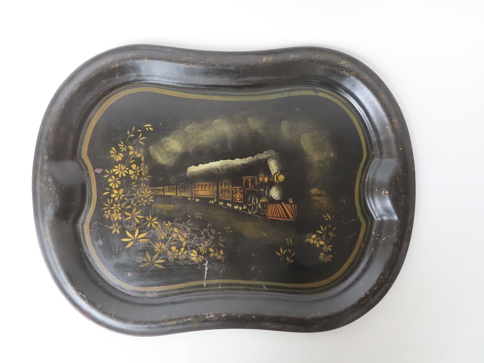 An unusual toleware tray with deep impression and handles each end, having an image of a stenciled: An unusual toleware tray with deep impression and handles each end, having an image of a stenciled steam locomotive in the center. Some wear and surface scratches, but overall good condition, circa 18