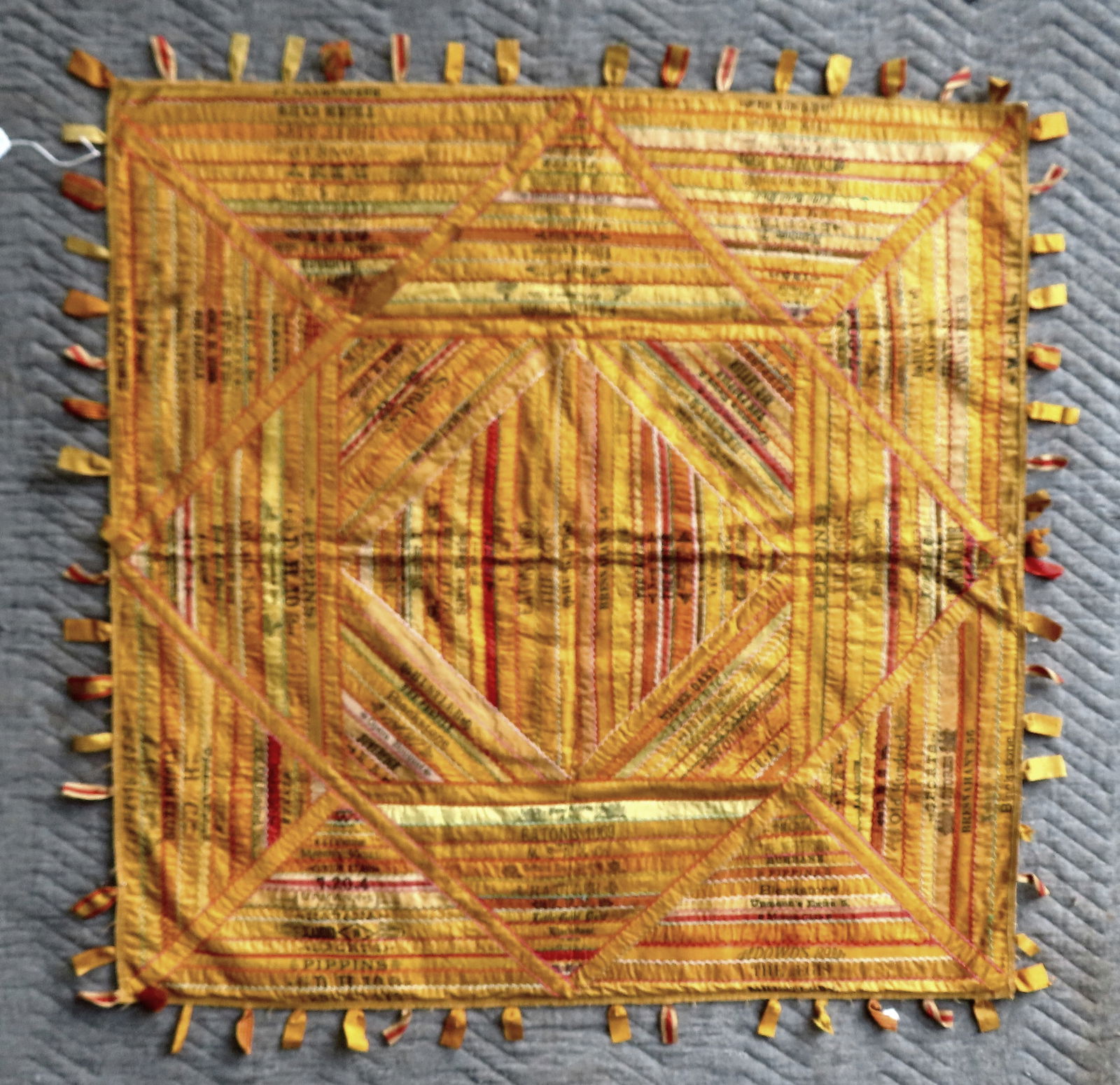 A very fine folk art silk tobacco quilt. Sewn with strips of tobacco silk or satin ribbons to create: A very fine folk art silk tobacco quilt. Sewn with strips of tobacco silk or satin ribbons to create a graphic crib quilt - the borders being machine sewn. These premiums were originally placed in pac