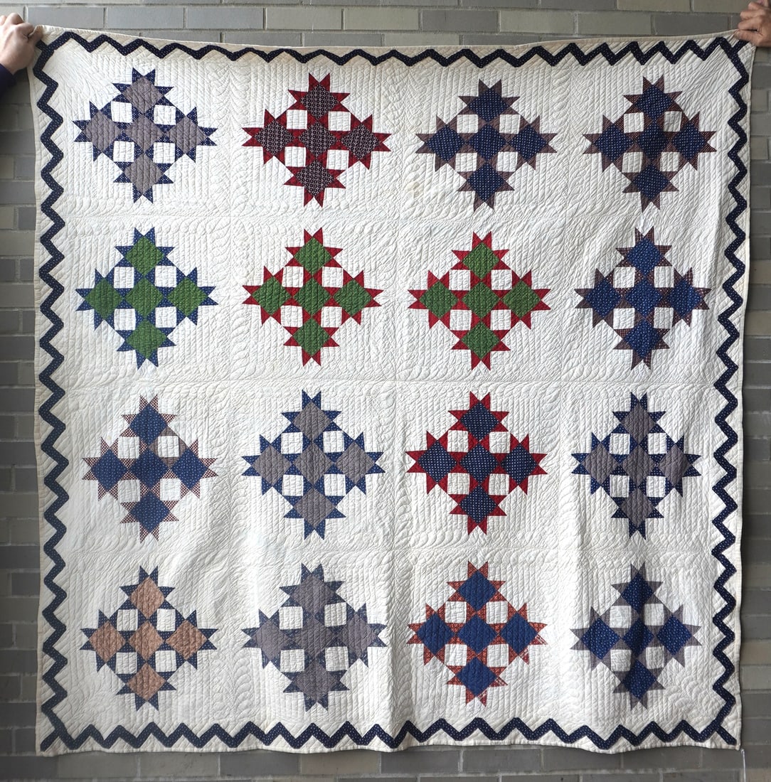 A good graphic Star-Cross pattern quilt (9-Patch variation), with zig-zag border and very fine: A good graphic Star-Cross pattern quilt (9-Patch variation), with zig-zag border and very fine feather quilting, late 19th century. Measures 75" x 75". All hand sewn in very good condition.