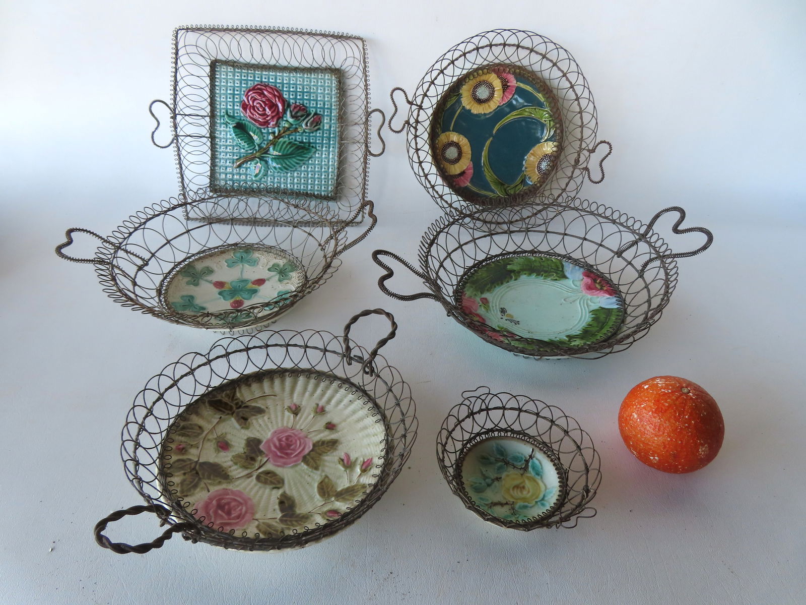 A grouping of 6 hand made wire baskets, all with majolica plates inserted as bases - includes 5 with: A grouping of 6 hand made wire baskets, all with majolica plates inserted as bases - includes 5 with heart shaped double handles, most likely German, late 19th century. Provenance: From the Marni Baks