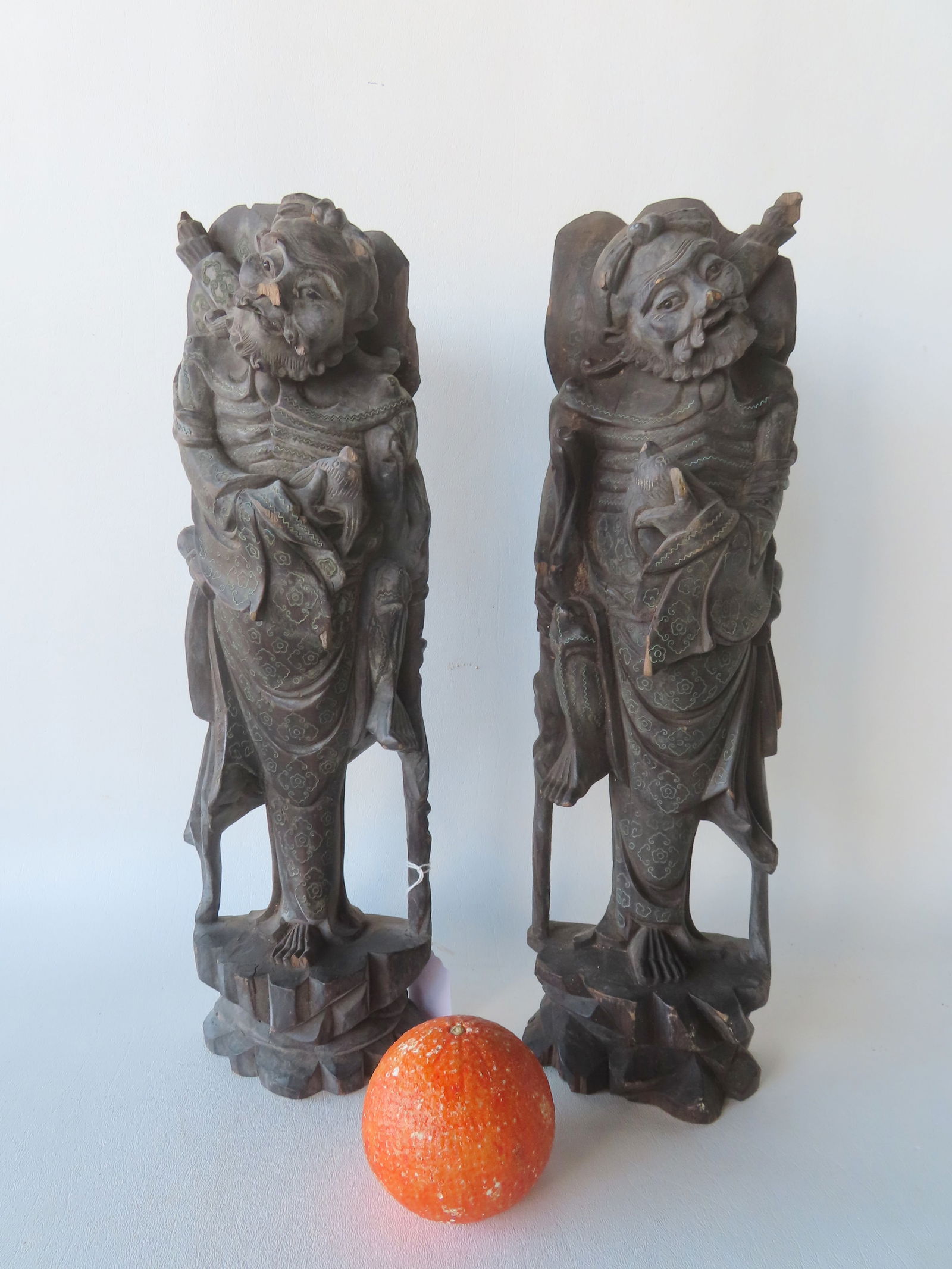 Two carved oriental wooden sculptures of bearded men with glass eyes, holding what appears to be a: Two carved oriental wooden sculptures of bearded men with glass eyes, holding what appears to be a bird (or fish) in one hand and having a human leg attached to their waste - 19th century - some losse