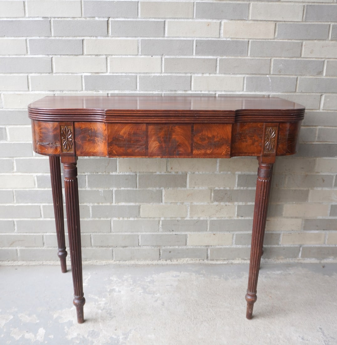 A Sheraton mahogany flip top game table with shaped front and tapered reeded legs, and having carved (1 of 19)