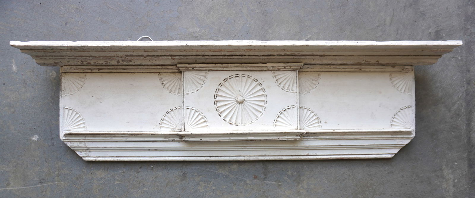 A make-do wall shelf with very fine shell carvings across the frieze board, in old white paint. (1 of 4)