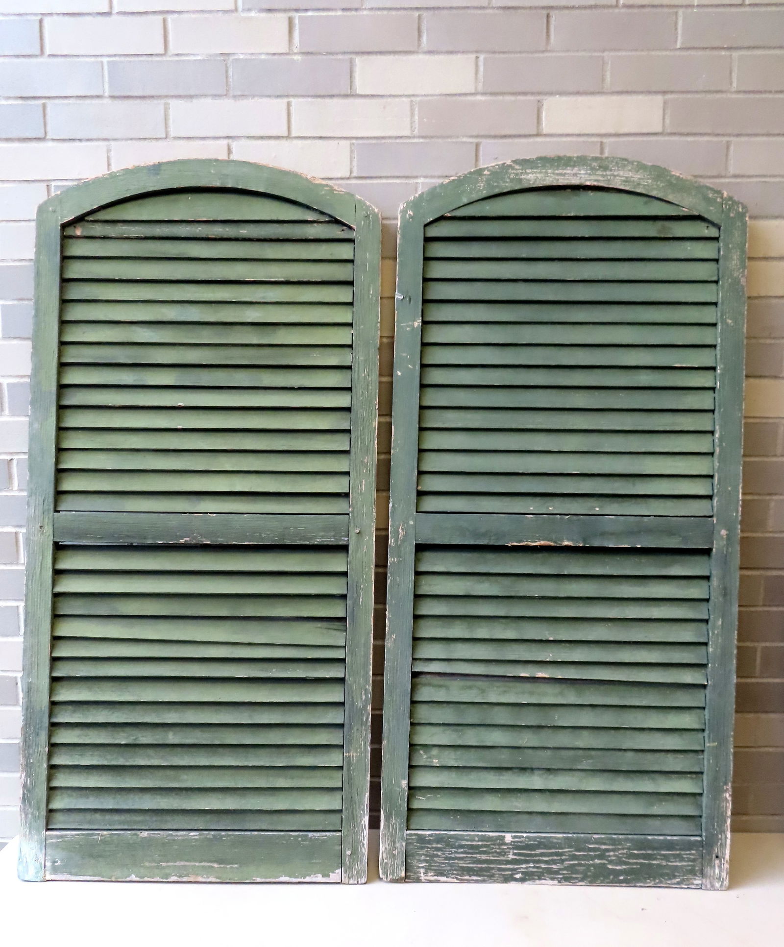 A pair or dome top shutters, mortise and tenon construction, original green paint on exterior side,: A pair or dome top shutters, mortise and tenon construction, original green paint on exterior side, reverse side not painted - mid 19th century - some typical paint wear, and overall good condition. M