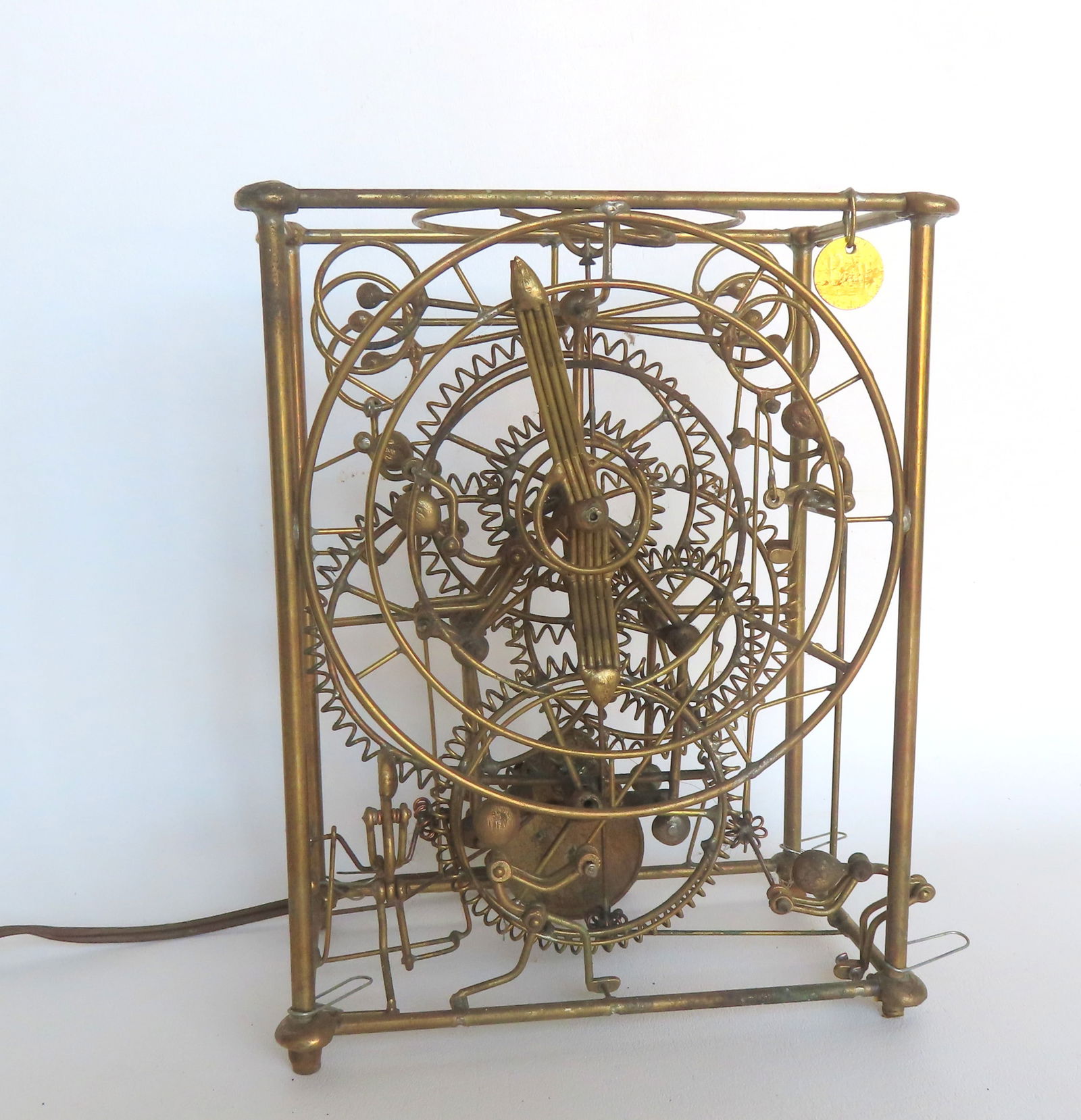 A Gordon Brandt Six Man electric clock, made by Kinetico Studios with an attached signed "Bradt": A Gordon Brandt Six Man electric clock, made by Kinetico Studios with an attached signed "Bradt" penny tag. Features six "men" who rotate the wheels and levers to give the appearance of driving the cl