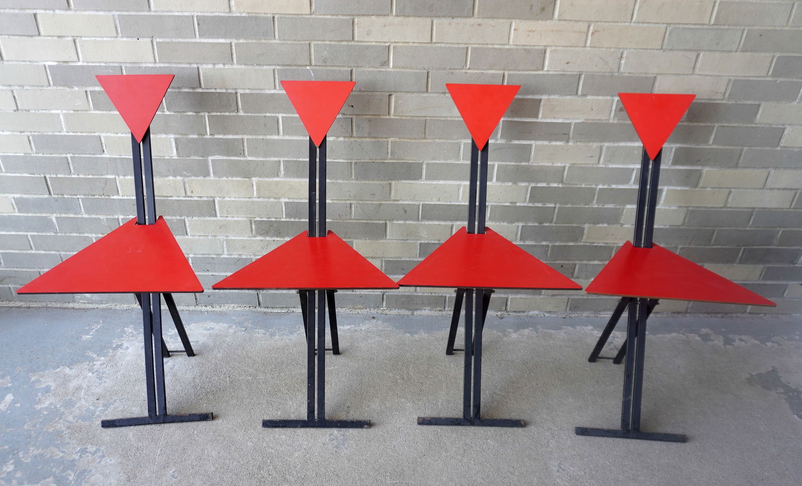 Set of 4 mid-century modern style geometric folding chairs, each with red composition triangular: Set of 4 mid-century modern style geometric folding chairs, each with red composition triangular seats and backs, attached to painted metal legs. Each measures in open position 16 1/2"W x 18 1/2"D x 3