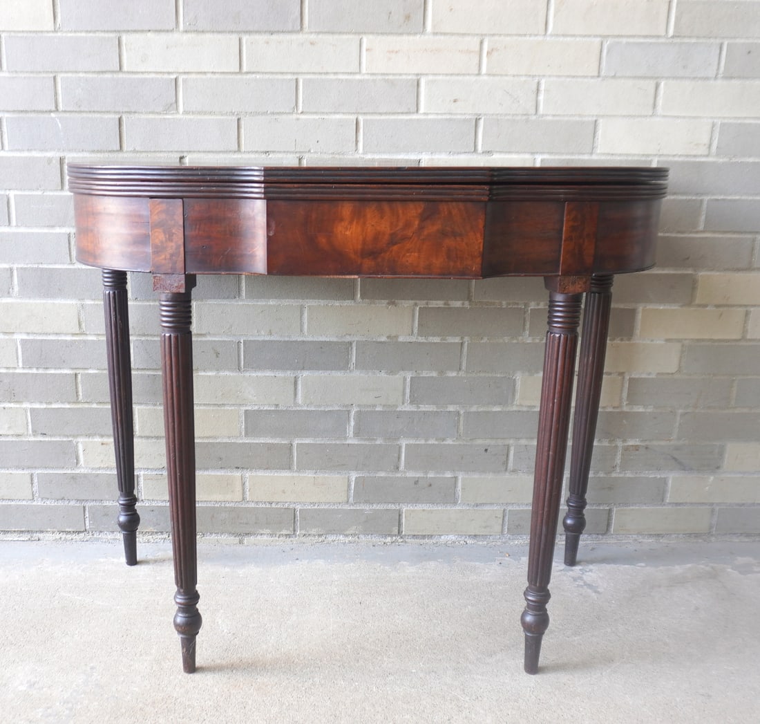 A Sheraton mahogany flip top game table with shaped front, reeded edge to top, reeded legs leading (1 of 20)
