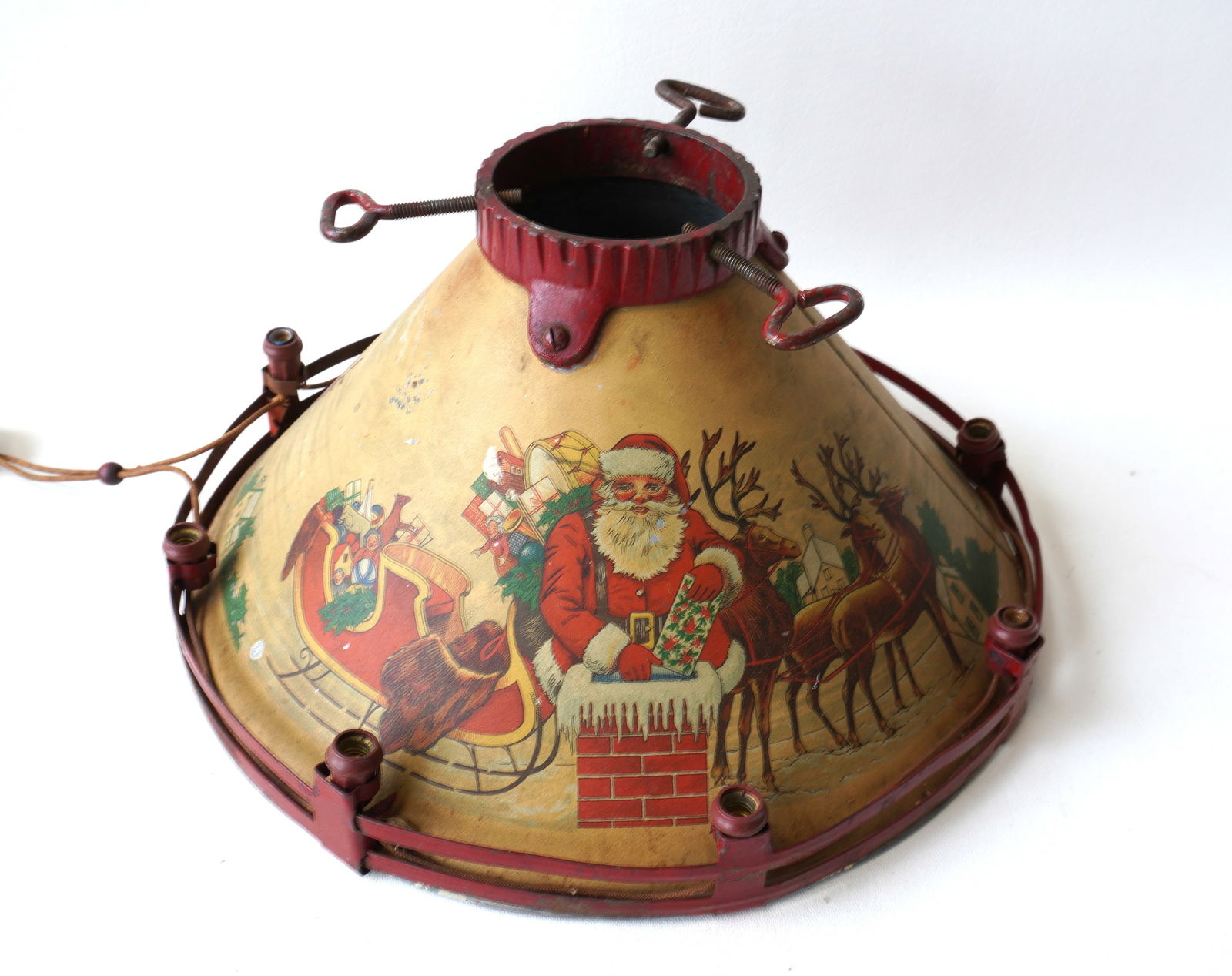 A NOMA lighted Christmas tree stand, cast iron and tin, with lights attached to border fencing at: A NOMA lighted Christmas tree stand, cast iron and tin, with lights attached to border fencing at base and signed NOMA TREE STAND - 340 Hudson St. New York City - based on this address, this stand cir