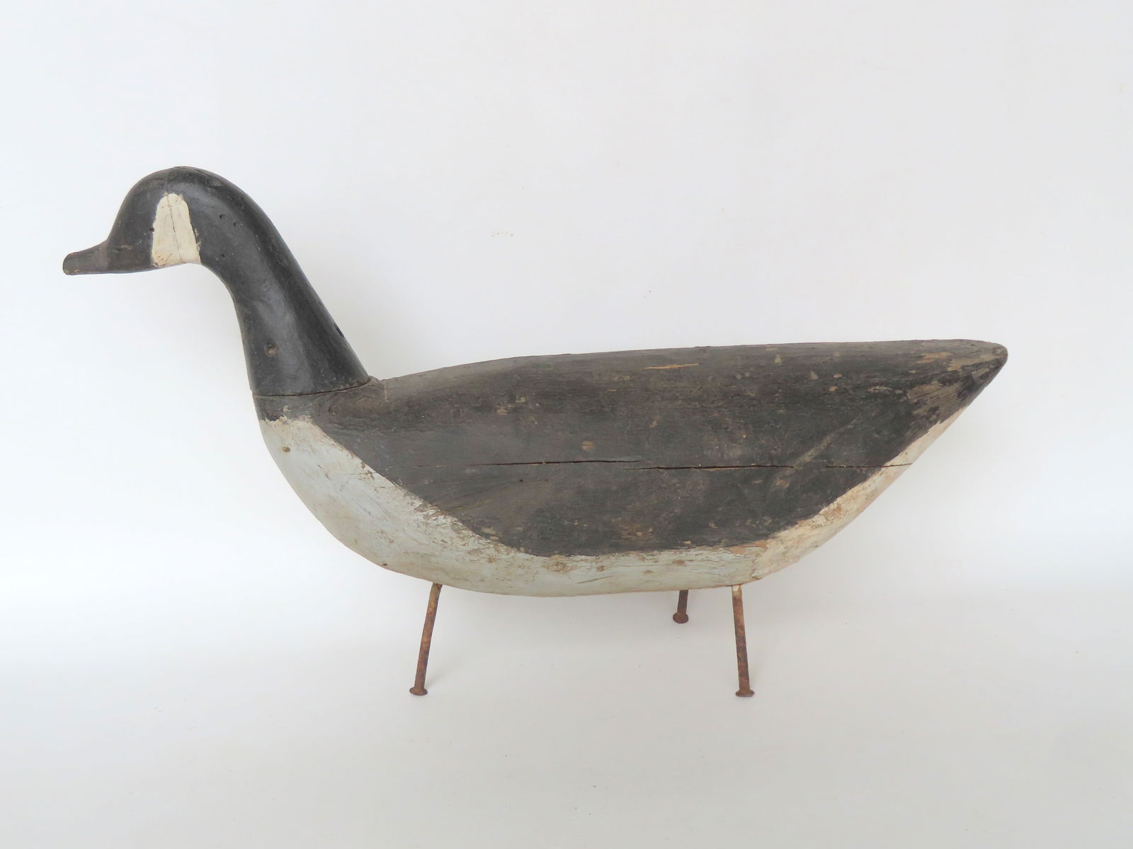 A carved wooden goose decoy with spiked iron legs, in original paint, probably Prince Edward Island. (1 of 6)