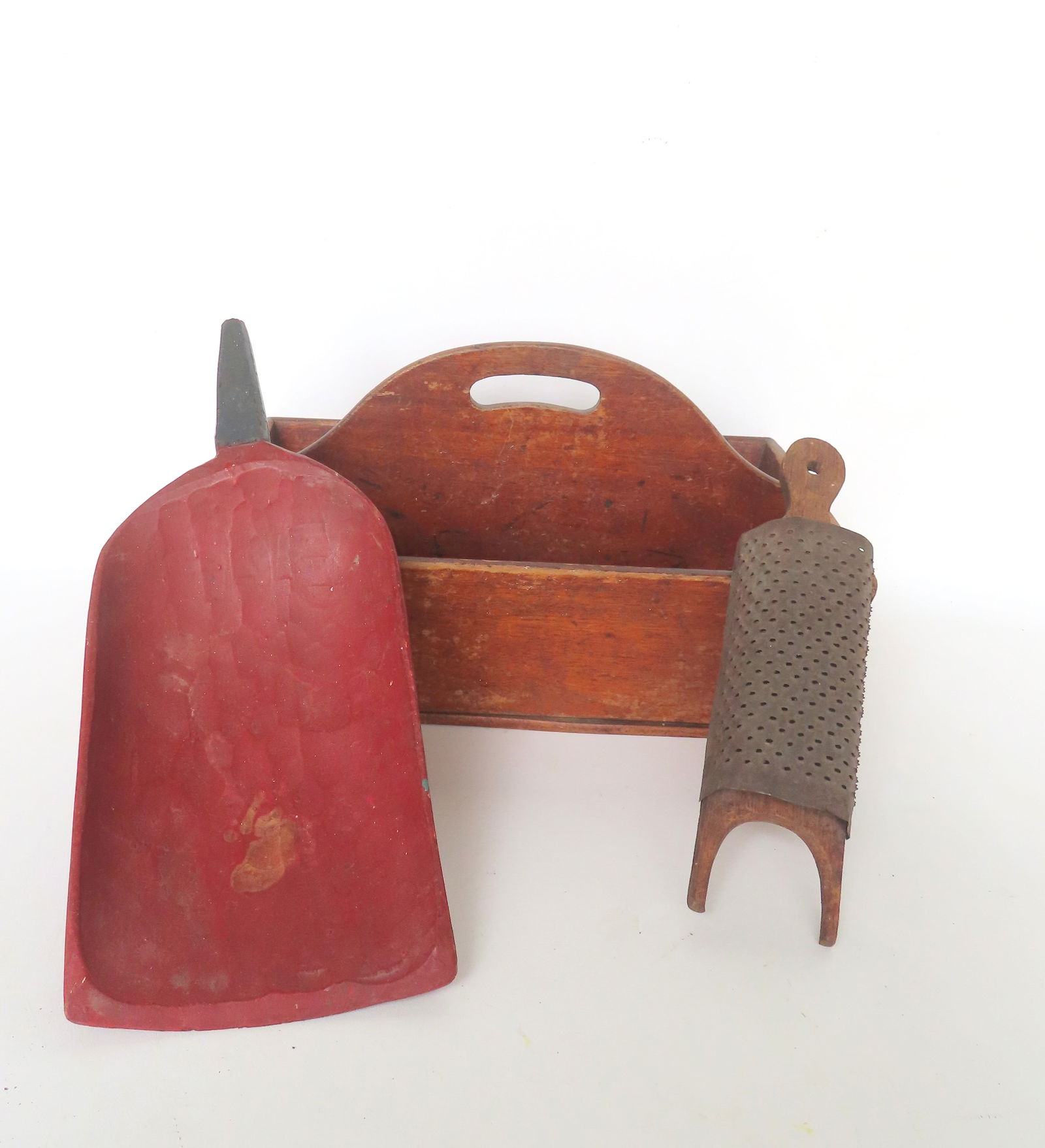 Three country collectibles, all 19th century, including: Cutlery box with dovetailed sides, a hand: Three country collectibles, all 19th century, including: Cutlery box with dovetailed sides, a hand made wooden grain scoop in original red paint, and a tin spice grater. All in good condition.