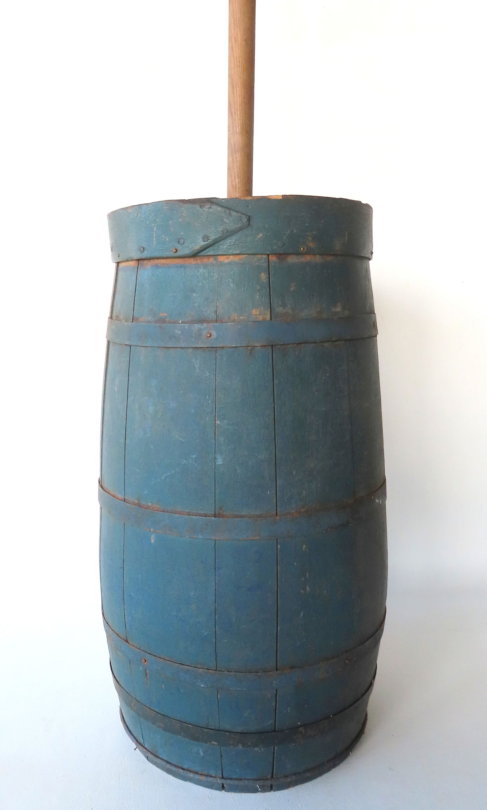 An early floor standing butter churn in original blue paint, early to mid 19th century, includes: An early floor standing butter churn in original blue paint, early to mid 19th century, includes dasher. The top collar has been broken and repaired, bottom iron strap reinforced with newer pin nails,