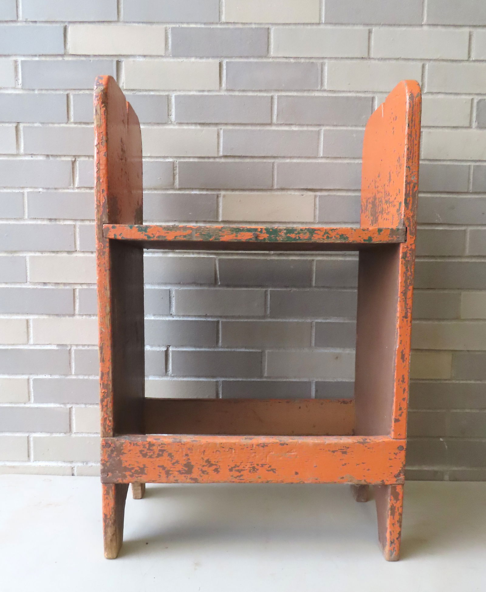A small primitive bucket bench with single shelf and 1/2 moon cutouts on side, circa mid 19th: A small primitive bucket bench with single shelf and 1/2 moon cutouts on side, circa mid 19th century, in an older orange paint. Measures 19 1/4"W x 11 3/4"D x 30 1/4"H. Paint loss, but overall good c