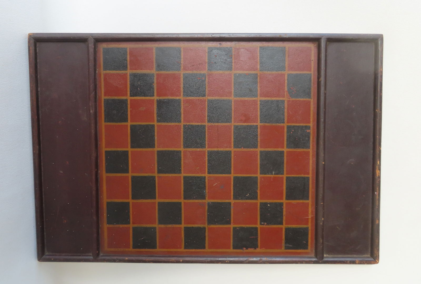 A hand painted game board with red and black squares with yellow border, on Masonite board, circa (1 of 4)