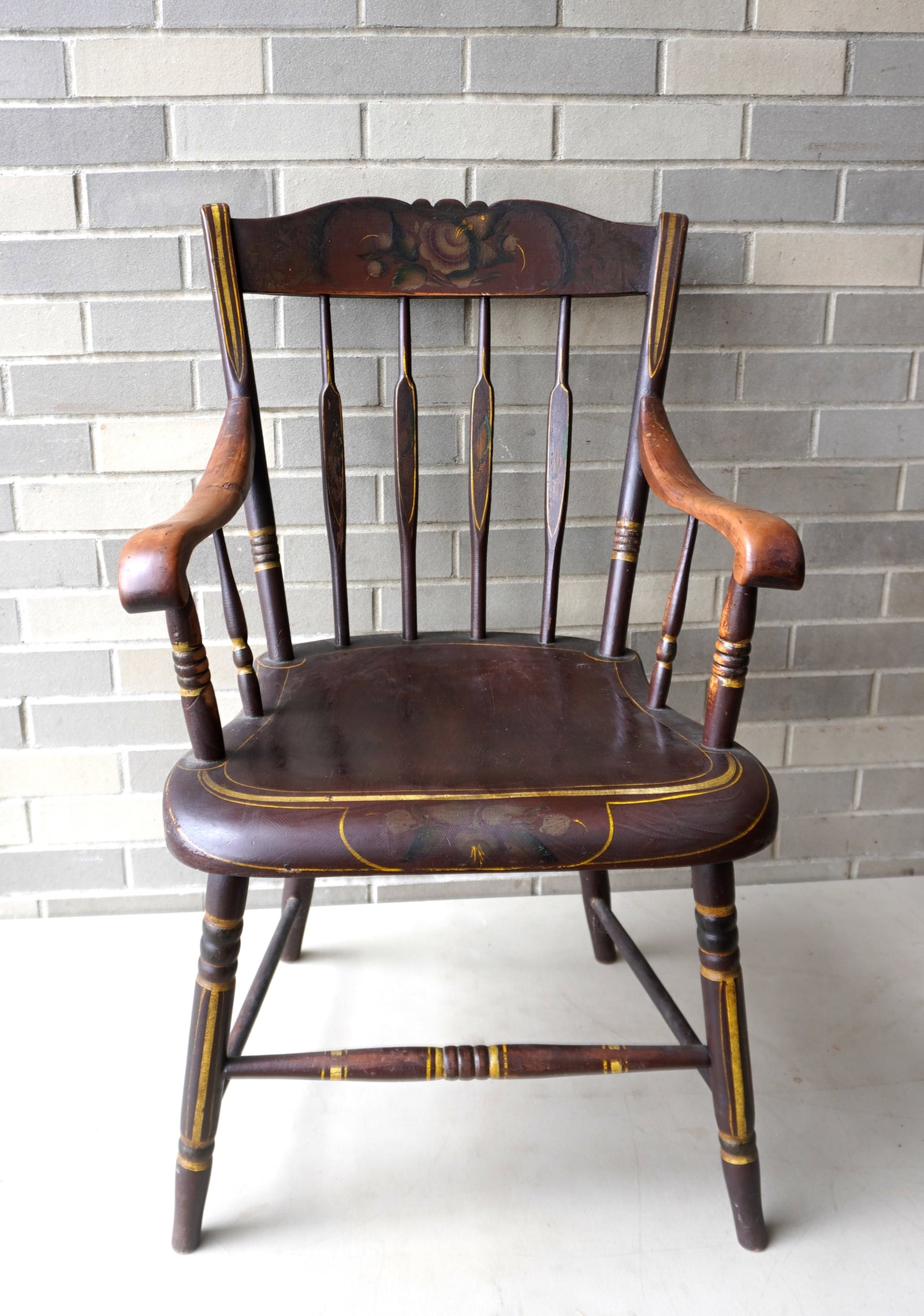 A Pennsylvania arrow-back arm chair with rabbit ears, shaped seat, in original paint, early 19th: A Pennsylvania arrow-back arm chair with rabbit ears, shaped seat, in original paint, early 19th century - the back splat decorated with flowers and leaves as is the front seat apron - yellow pin stri