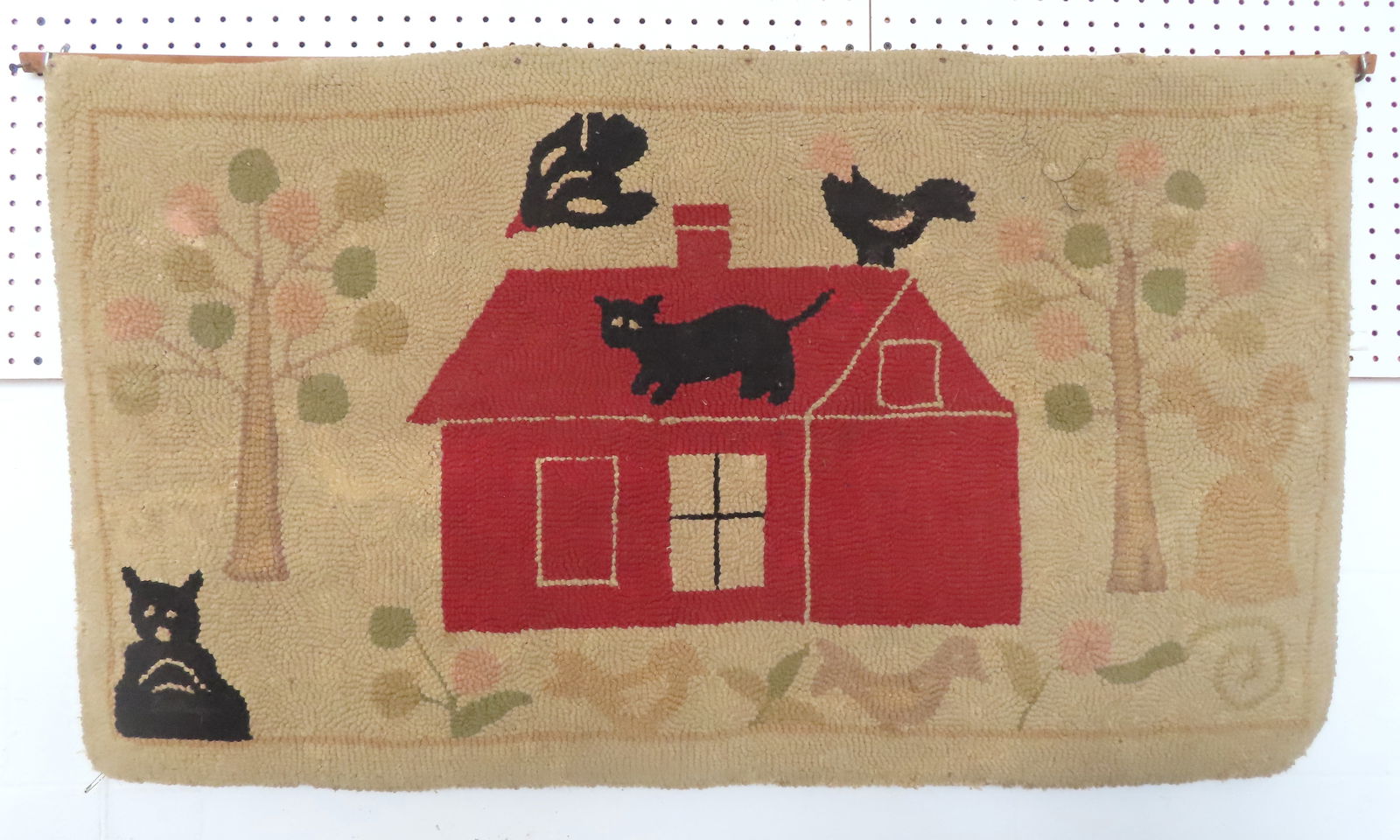 A folk art hooked rug depicting a black cat standing on the roof of a red barn with nearby crows - (1 of 2)