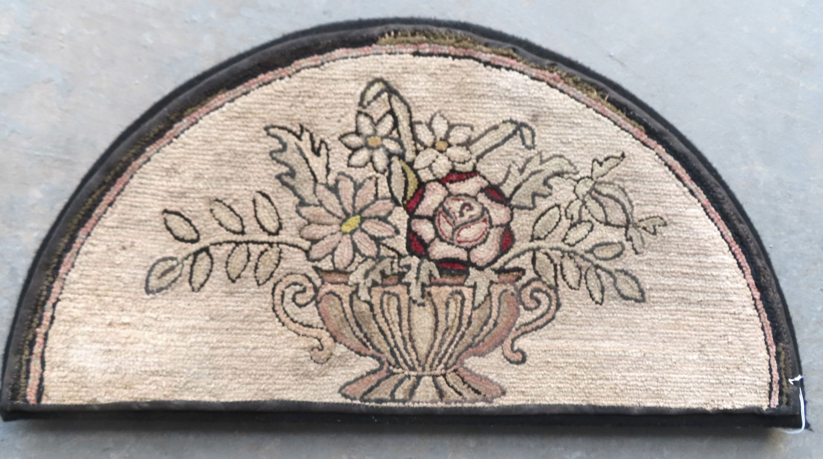 A professionally mounted pictorial 1/2 round entrance-way hooked rug, decorated with a double handle: A professionally mounted pictorial 1/2 round entrance-way hooked rug, decorated with a double handle garden urn holding flowers, early 20th century. Good condition. Measures 31 1/2"W x 15 1/2"H.