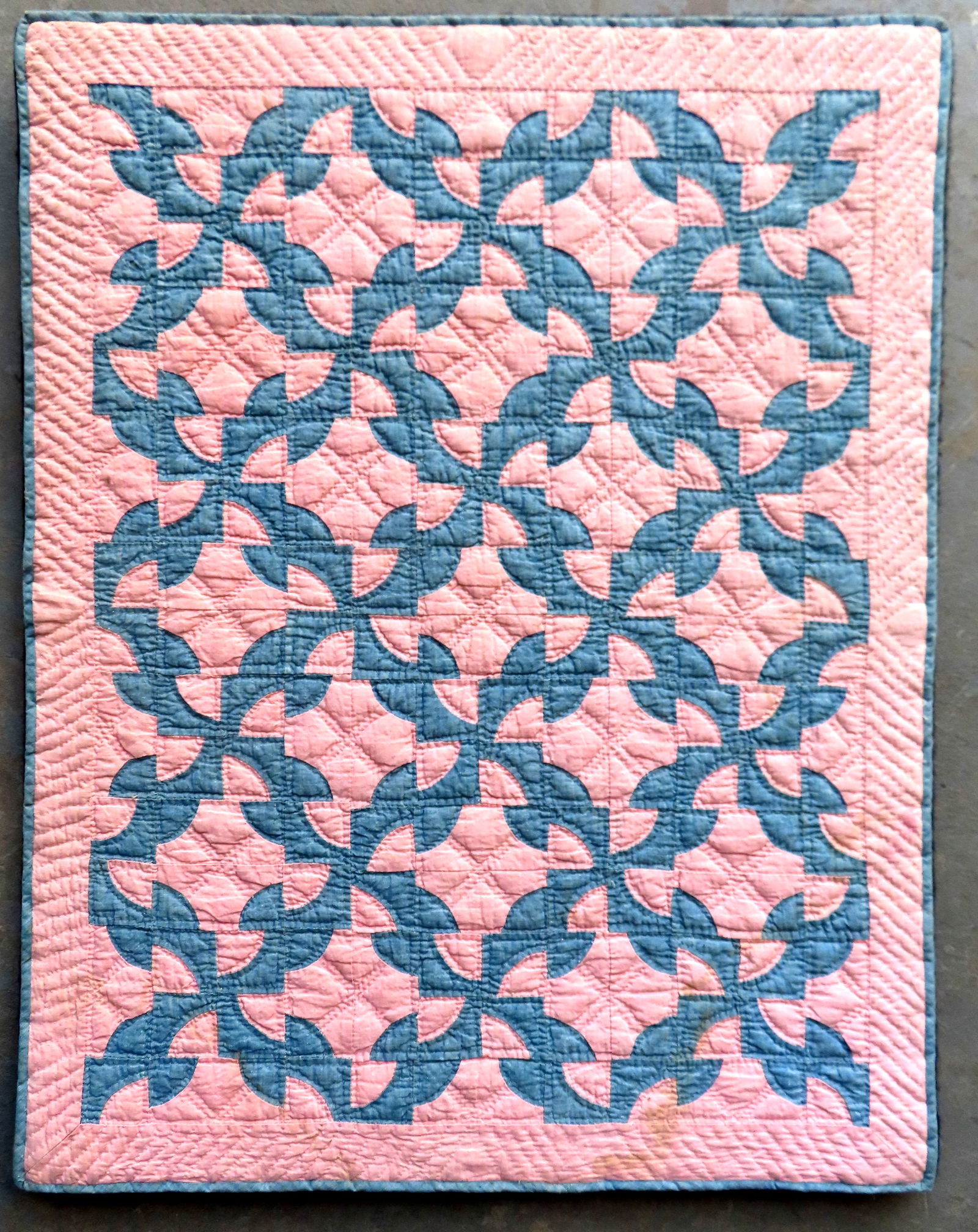 A mounted crib quilt in Drunkard Path pattern, all hand sewn in blue and pink fabric, mid to late (1 of 4)