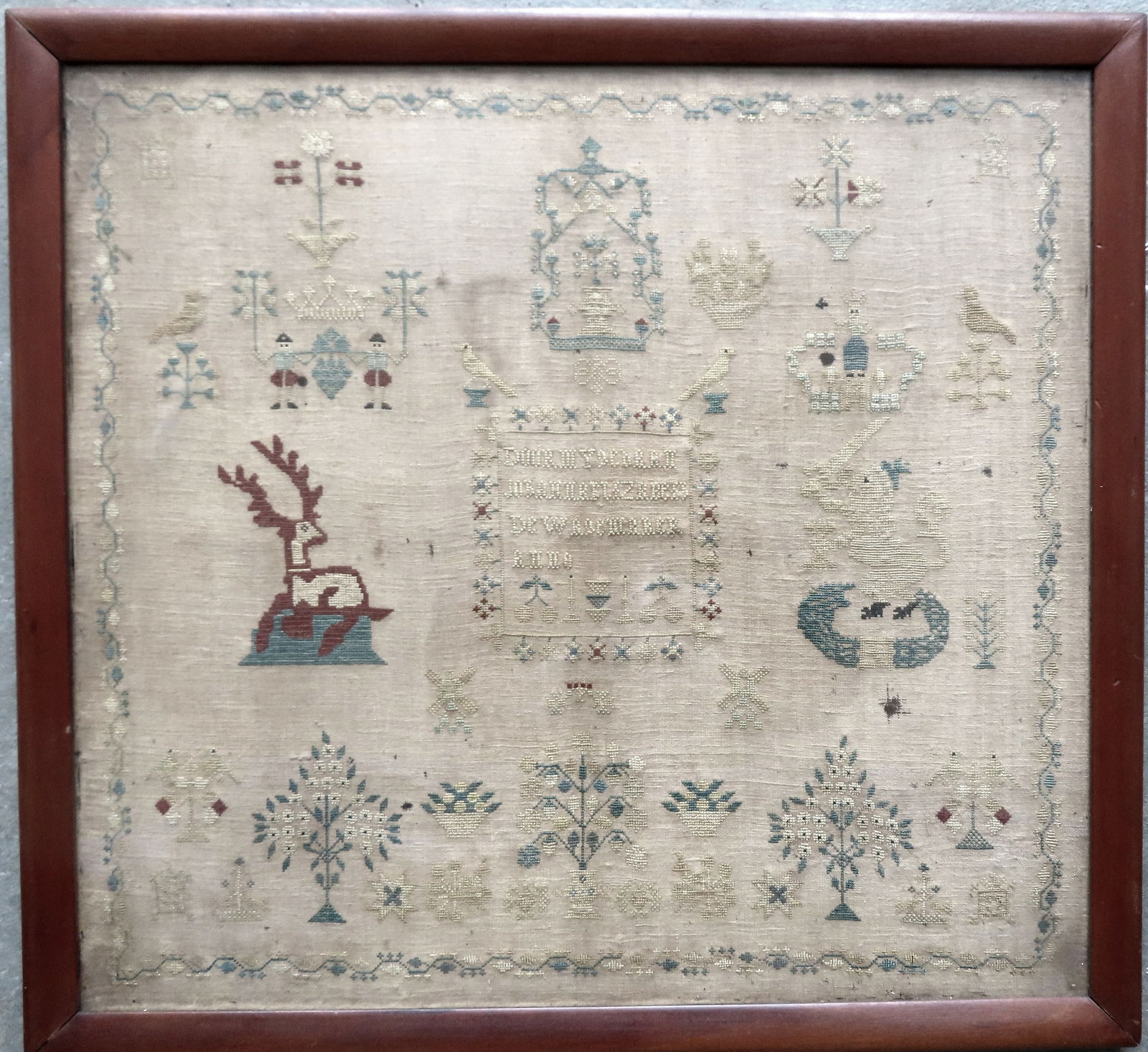 A continental needlework sampler decorated with crowns, stars, flowers, trees with birds, figures, a: A continental needlework sampler decorated with crowns, stars, flowers, trees with birds, figures, a resting stag deer, a coat of arms depicting a lion wearing crown holding sword, etc. The needlework