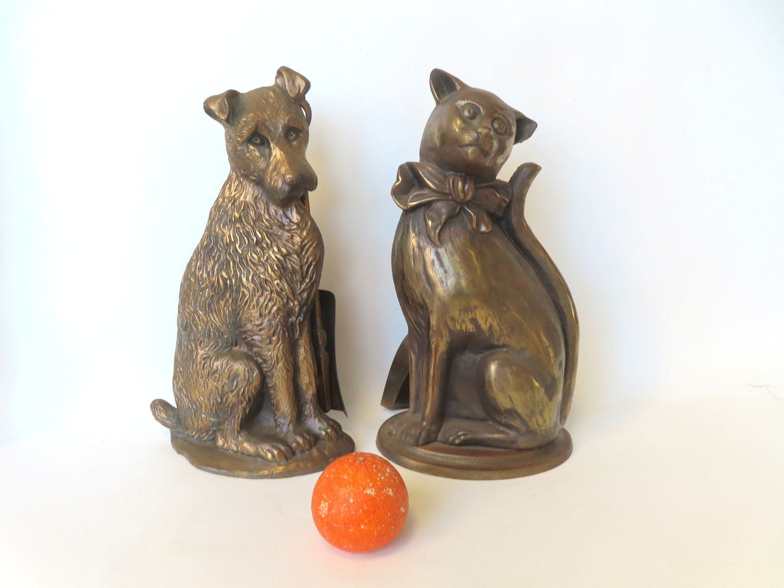 Two figural cast iron fireplace tool holders with bronze finish, in the form of a Spaniel dog and: Two figural cast iron fireplace tool holders with bronze finish, in the form of a Spaniel dog and cat with bowtie - signed "Nestor / (registration #) / Made in England". Both 14 1/2"H x 8 1/2"W and in