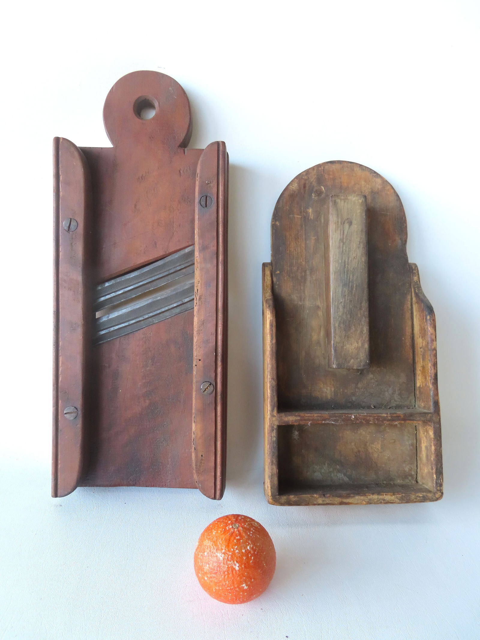 Two country kitchen collectibles, both likely mid 19th century, including: An early wood and iron ca: Two country kitchen collectibles, both likely mid 19th century, including: An early wood and iron cabbage slicer in red stain; and a wall mount wooden knife sharpener. Both in very good condition.
