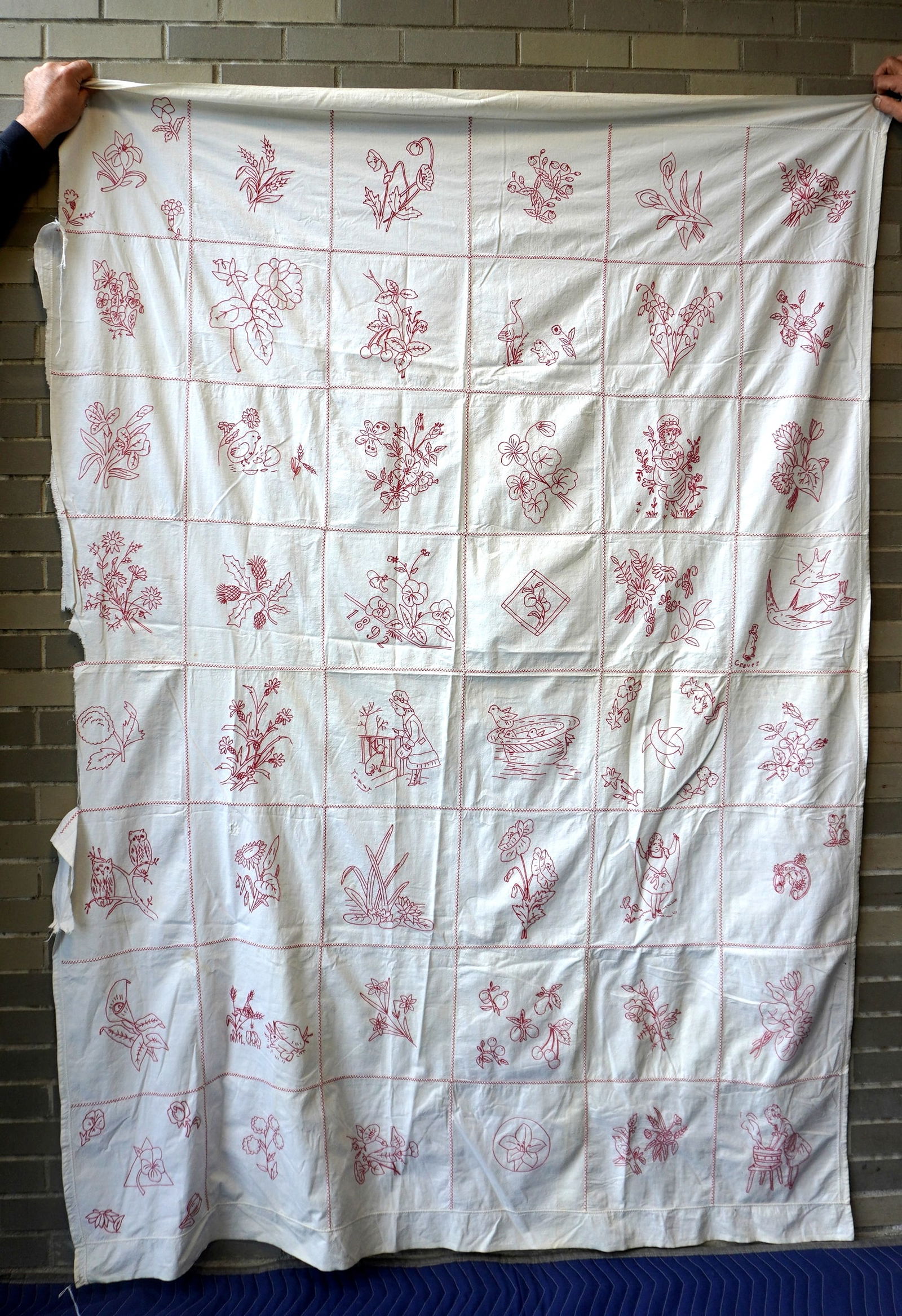 A child's hand sewn red and white bed sheet decorated with 48 images, including flowers, birds, (1 of 14)