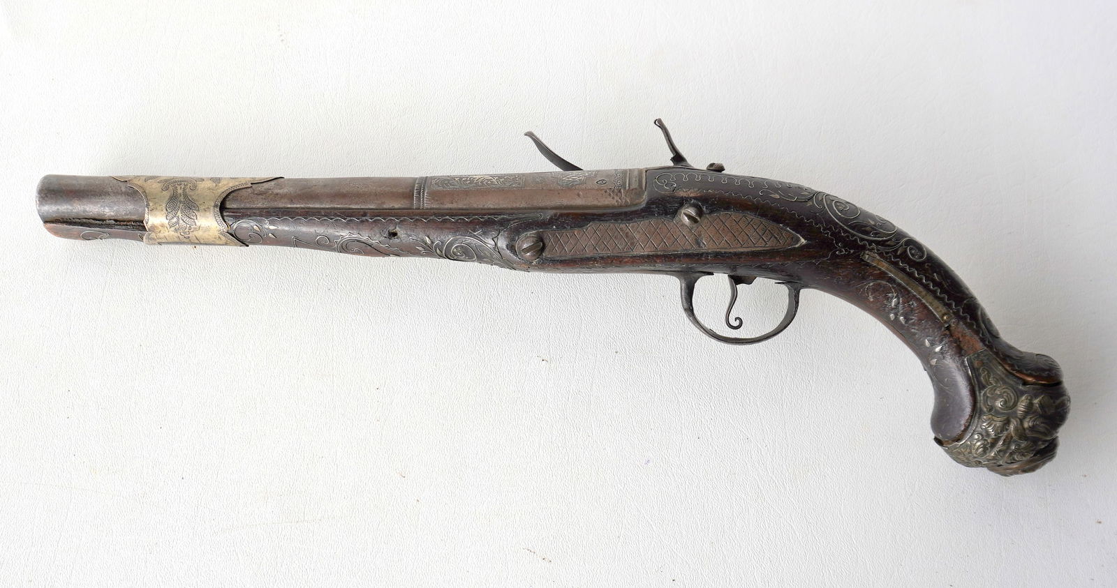 A Persian flintlock pistol, 18th century, having an ornate brass butt cap, engraved lock plates, and (1 of 20)