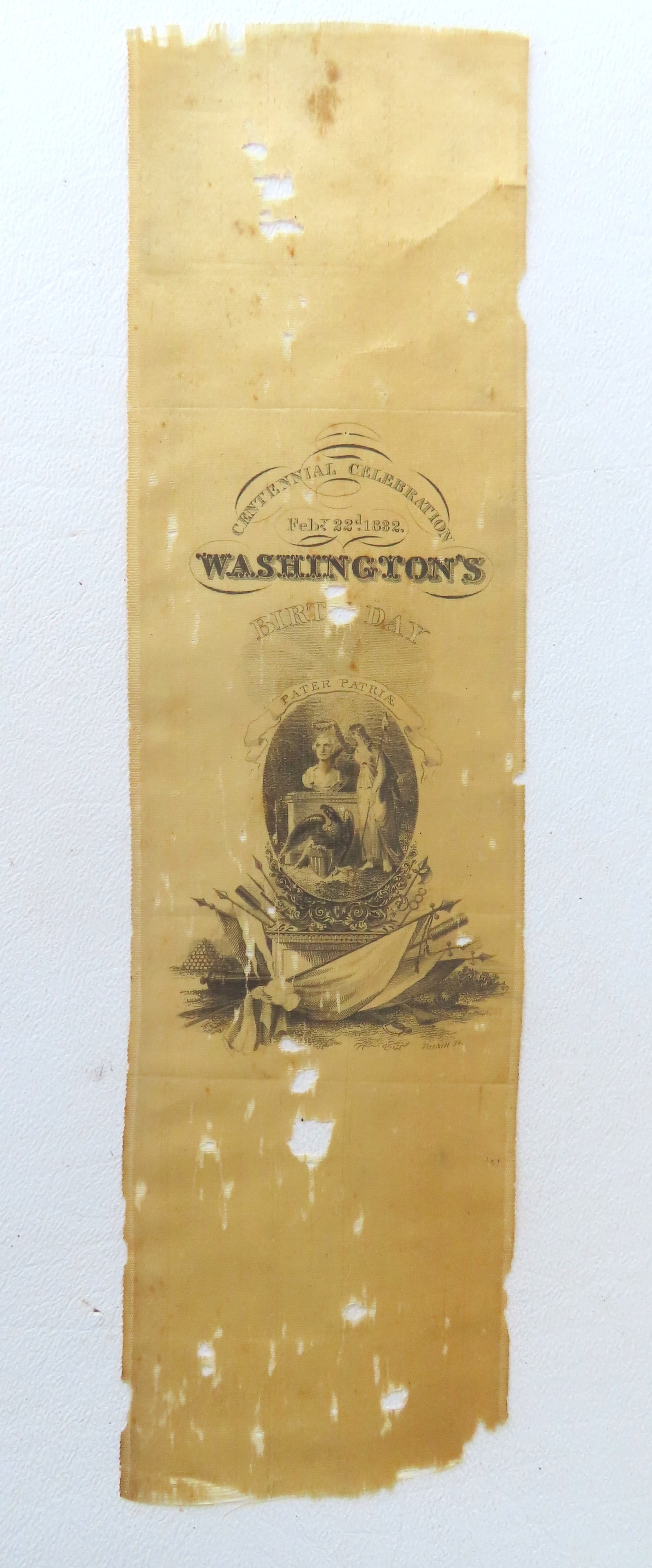 A Centennial ribbon in celebration of George Washington's birthday dated Feby 22nd 1832 - measures 9: A Centennial ribbon in celebration of George Washington's birthday dated Feby 22nd 1832 - measures 9 3/4"L - fair condition with holes in ribbon.