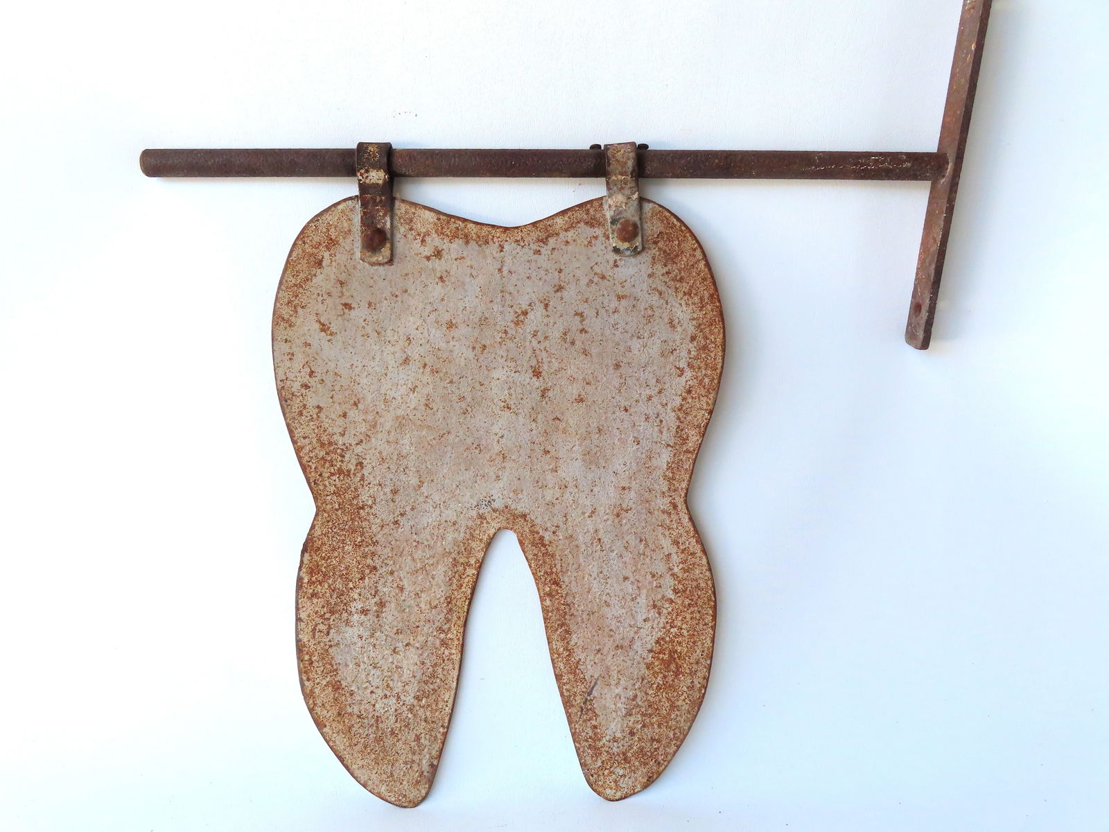 A folk art Dentist sheet iron trade sign in original gray paint, hand forged iron parts, 19th: A folk art Dentist sheet iron trade sign in original gray paint, hand forged iron parts, 19th century. The sign hangs from hinges attached to an iron rod that is attached to a bracket that would faste