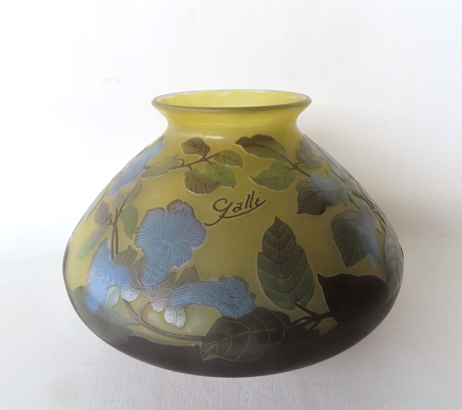 A signed Galle cameo glass vase decorated in relief with blue bell flowers on tree branch with leave: A signed Galle cameo glass vase decorated in relief with blue bell flowers on tree branch with leaves. Measures 10 3/4"W x 7 1/4"H. Very good condition, no damage or repairs. Provenance: From the Marn