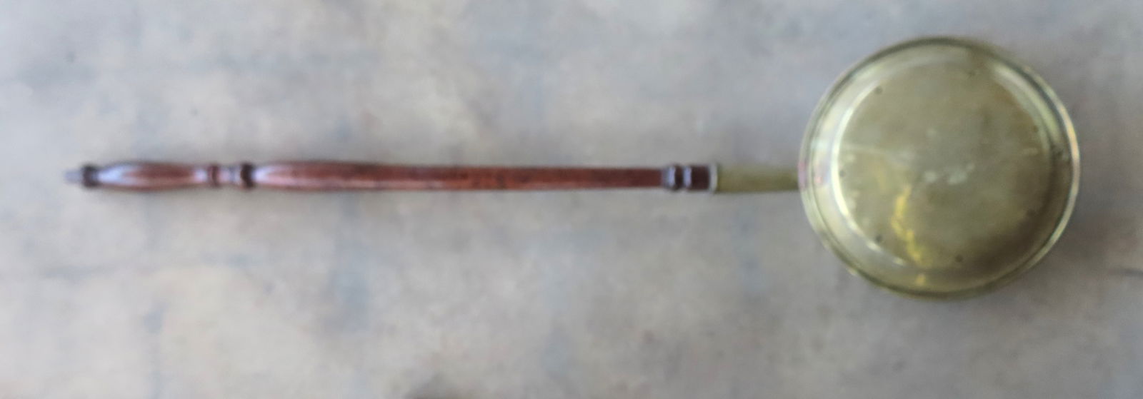 An early 19th century brass bedwarmer with engraved flowers on the brass lid and having a grain pain: An early 19th century brass bedwarmer with engraved flowers on the brass lid and having a grain painted wooden handle. Measures 43 3/4"L x 11" diameter. Very good condition.