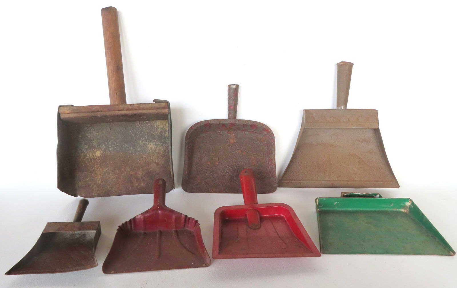 Grouping of 6 primitive tin dust pans, several hand made (most 19th century), and 1 hand made tin an: Grouping of 6 primitive tin dust pans, several hand made (most 19th century), and 1 hand made tin and wood grain scoop (19th century) - 13 1/2"L x 7 1/4"W. One of the hand made tin dust pans with an e