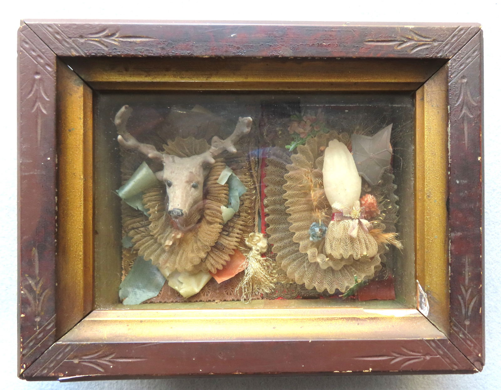 An unusual small size diorama depicting a molded stag deer mount, with glass eyes applied to a very: An unusual small size diorama depicting a molded stag deer mount, with glass eyes applied to a very fine lace double wreaths, and adjacent to a wax hand applied to the same similar lace double wreaths