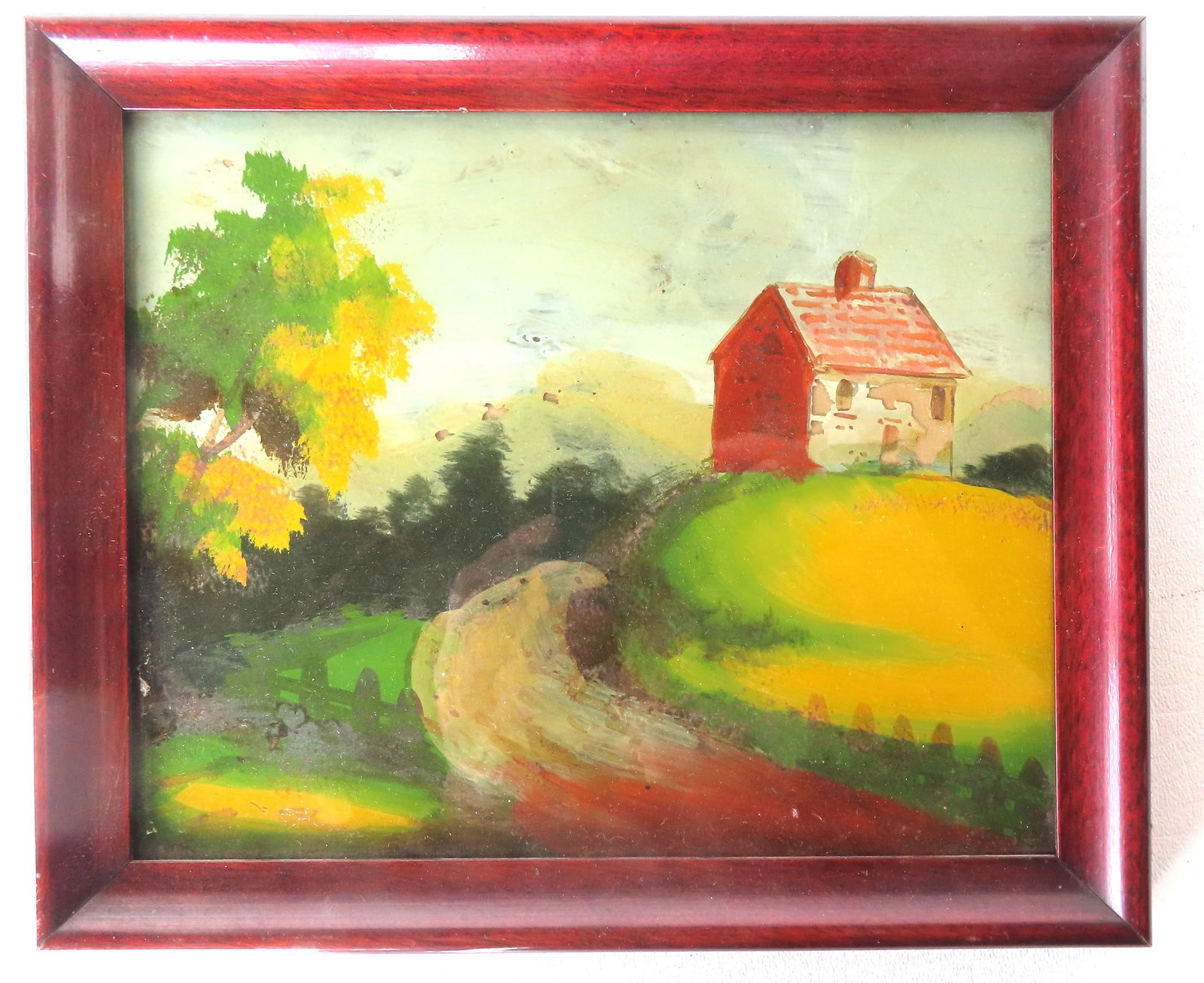 A small colorful landscape painting depicting farmhouse on hill, reverse painted on glass.: A small colorful landscape painting depicting farmhouse on hill, reverse painted on glass. Note the Boston MA. paper label applied to original backboard. Very good condition, circa 1900.