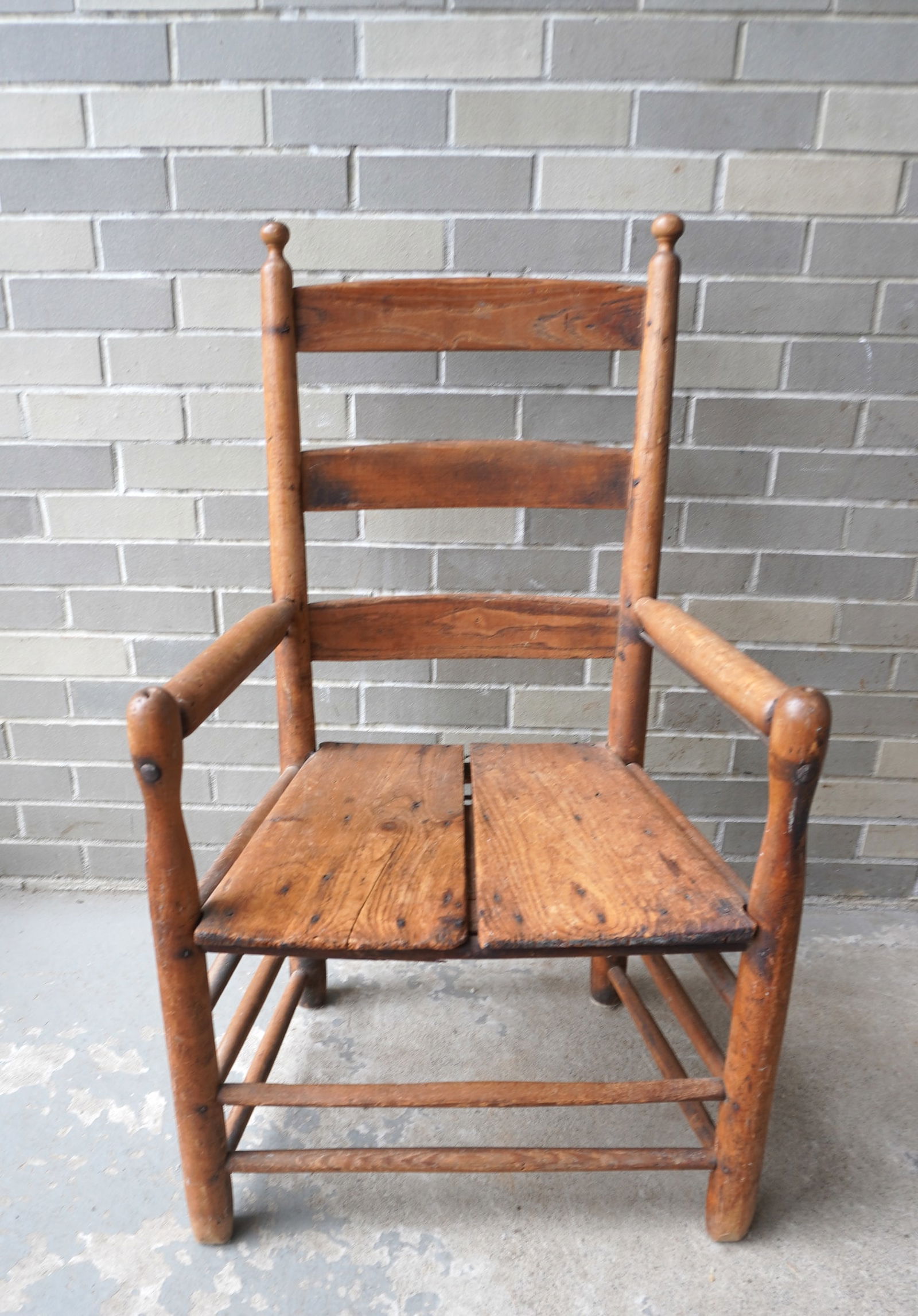 A primitive Hudson Valley ladder back chair with ball finials, and triple cross stretchers on sides,: A primitive Hudson Valley ladder back chair with ball finials, and triple cross stretchers on sides, mid 19th century. A very old seat replacement consisting of 2 worn wooden planks which gives it ext