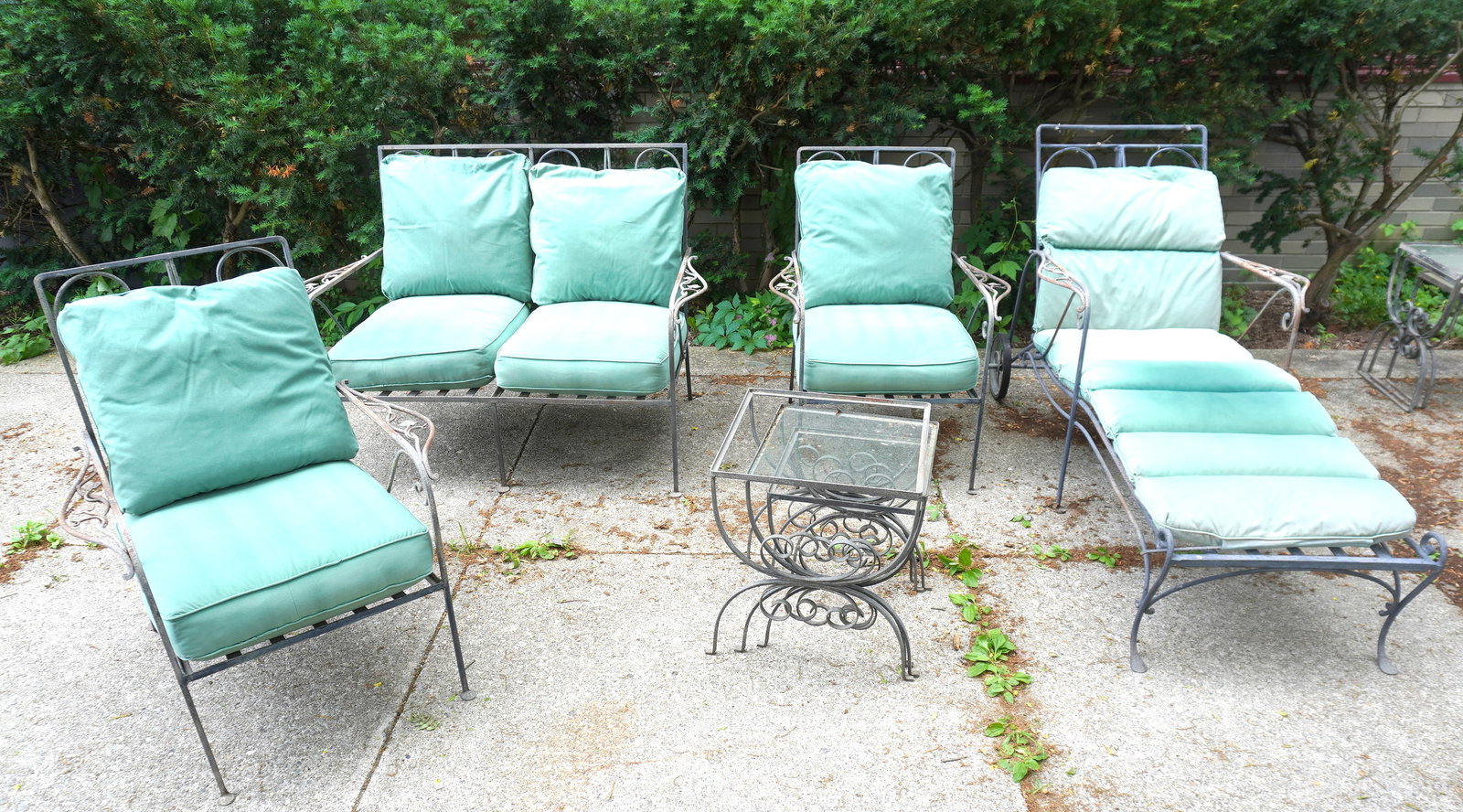 A high quality wrought iron matching patio set consisting of adjustable lounge with original rubber: A high quality wrought iron matching patio set consisting of adjustable lounge with original rubber wheels, a settee and 2 arm chairs, all in the manner of Woodard or Salterini - the chairs and lounge