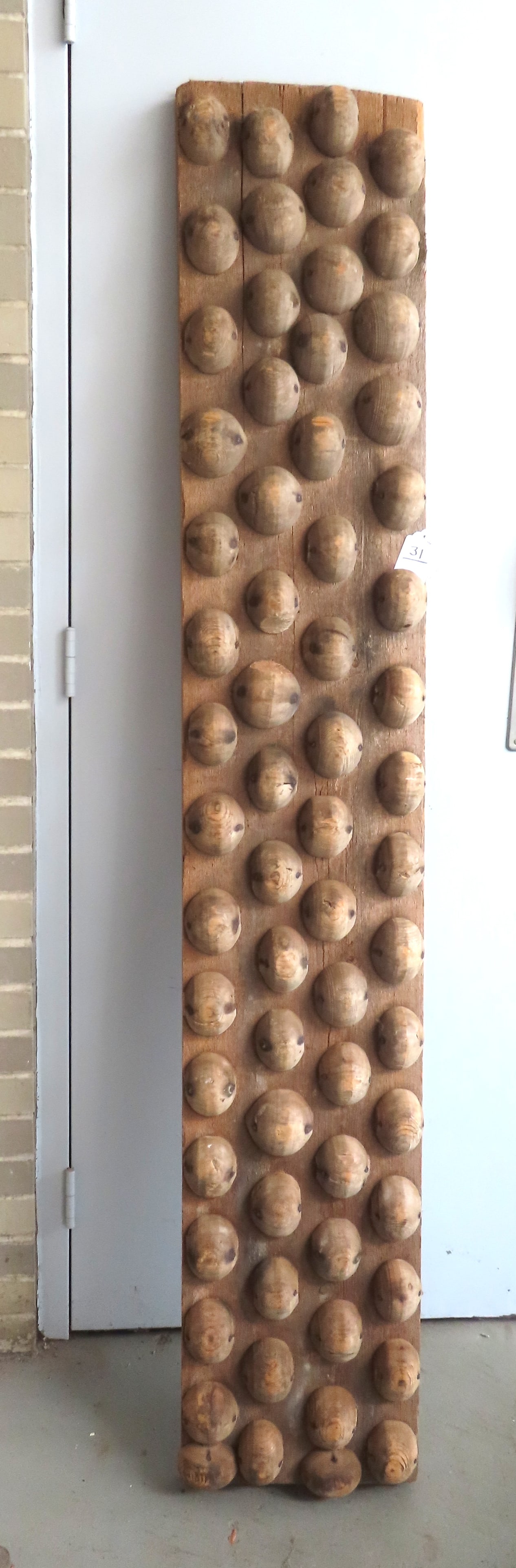 A large primitive architectural wooden utilitarian implement, possibly used in farming, but very: A large primitive architectural wooden utilitarian implement, possibly used in farming, but very sculptural with unknown use. The thick wooden plank has 4 rows of 1/2 round wooden "ornaments" attached