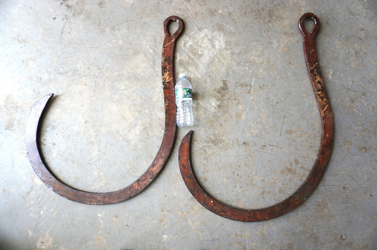 A pair of matching hand forged iron nautical rigging hooks, early to mid 19th century in very good: A pair of matching hand forged iron nautical rigging hooks, early to mid 19th century in very good condition. Both nearly the same size, but the largest measures 29 1/2"H x 25"W. Both in good conditio