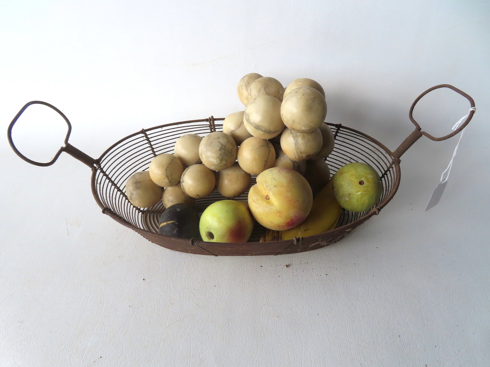 Grouping of 6 pieces of stone fruit held in an early double handle wire basket. Includes an (1 of 4)