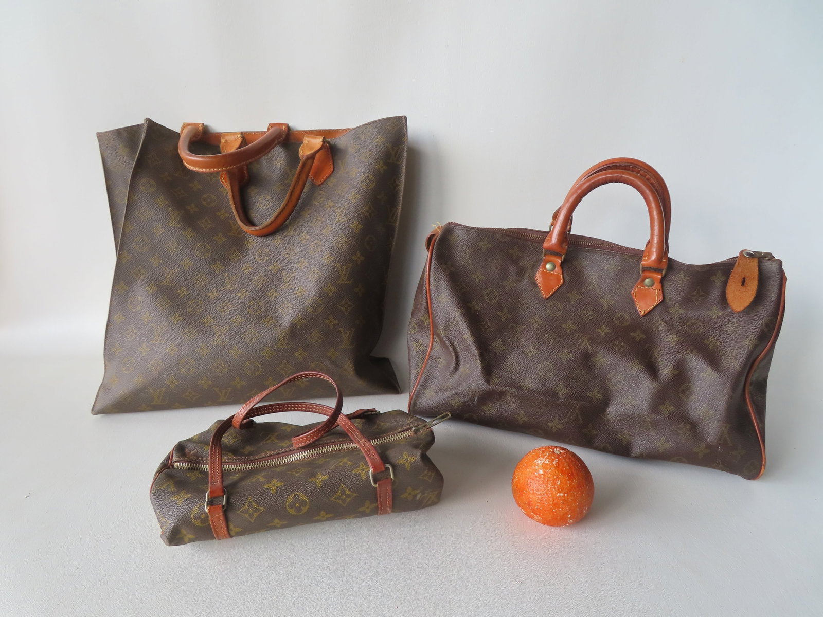 Grouping of 3 Louis Vuitton monogrammed lady's accessories including tote bag and 2 hand bags. They: Grouping of 3 Louis Vuitton monogrammed lady's accessories including tote bag and 2 hand bags. They all appear to predate 1980 and the only other symbol on a bag is YKK on a zipper - "YKK" stands for 