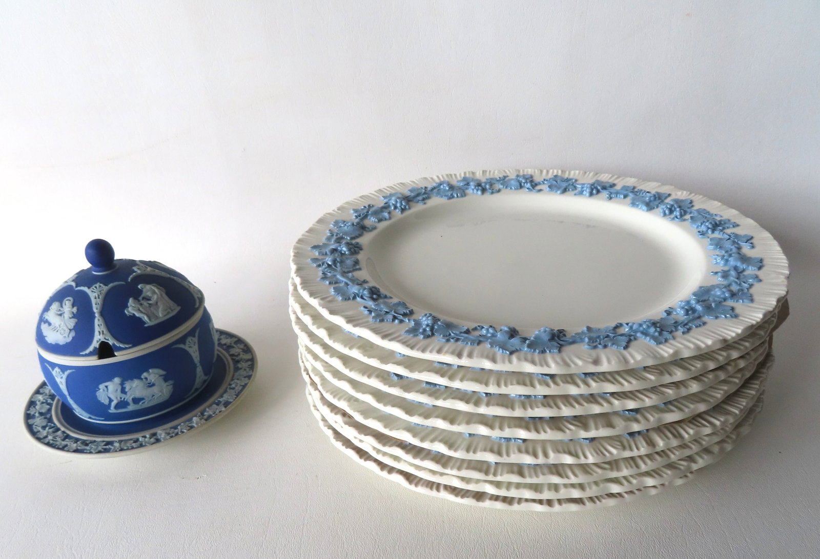 Grouping of Wedgwood including set of 8 Queen's Ware cream colored plates with embossed blue: Grouping of Wedgwood including set of 8 Queen's Ware cream colored plates with embossed blue decoration of grapes on vine - they appear unused in very good condition without damage or repairs - 10 1/4