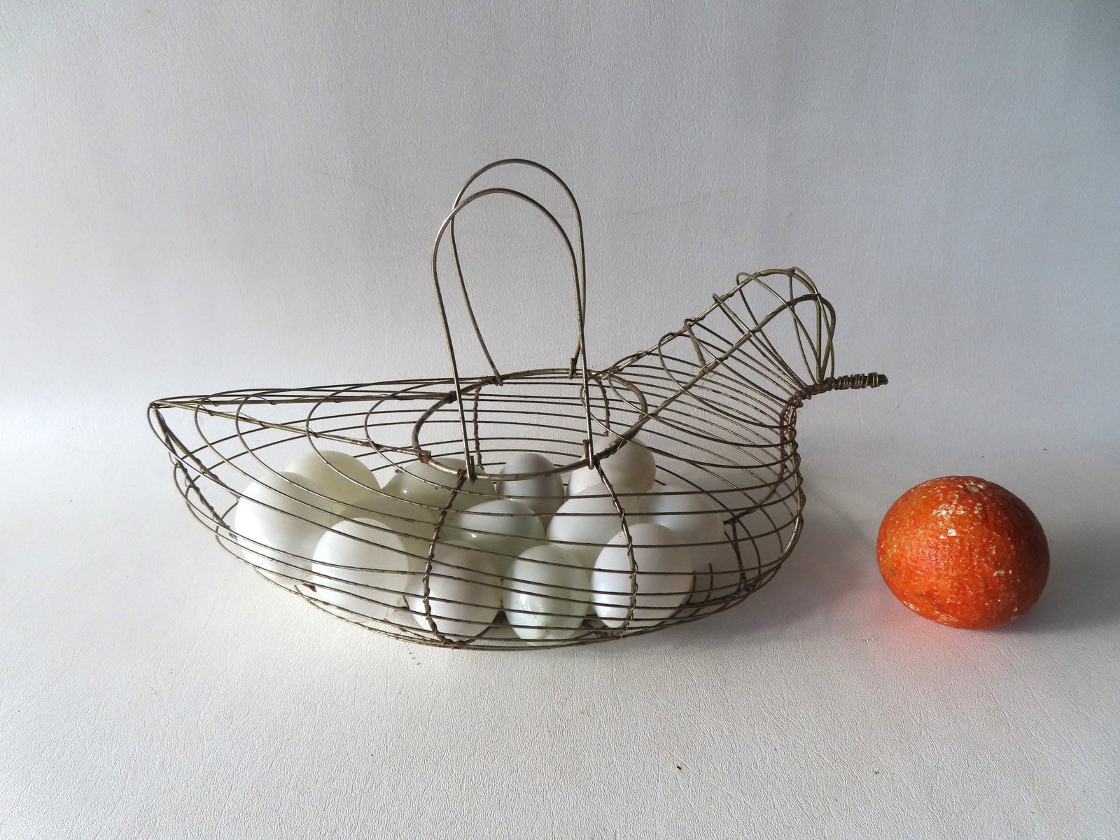 A wire chicken form egg holder/boiler currently housing 13 hand blown Victorian darning eggs. All (1 of 3)