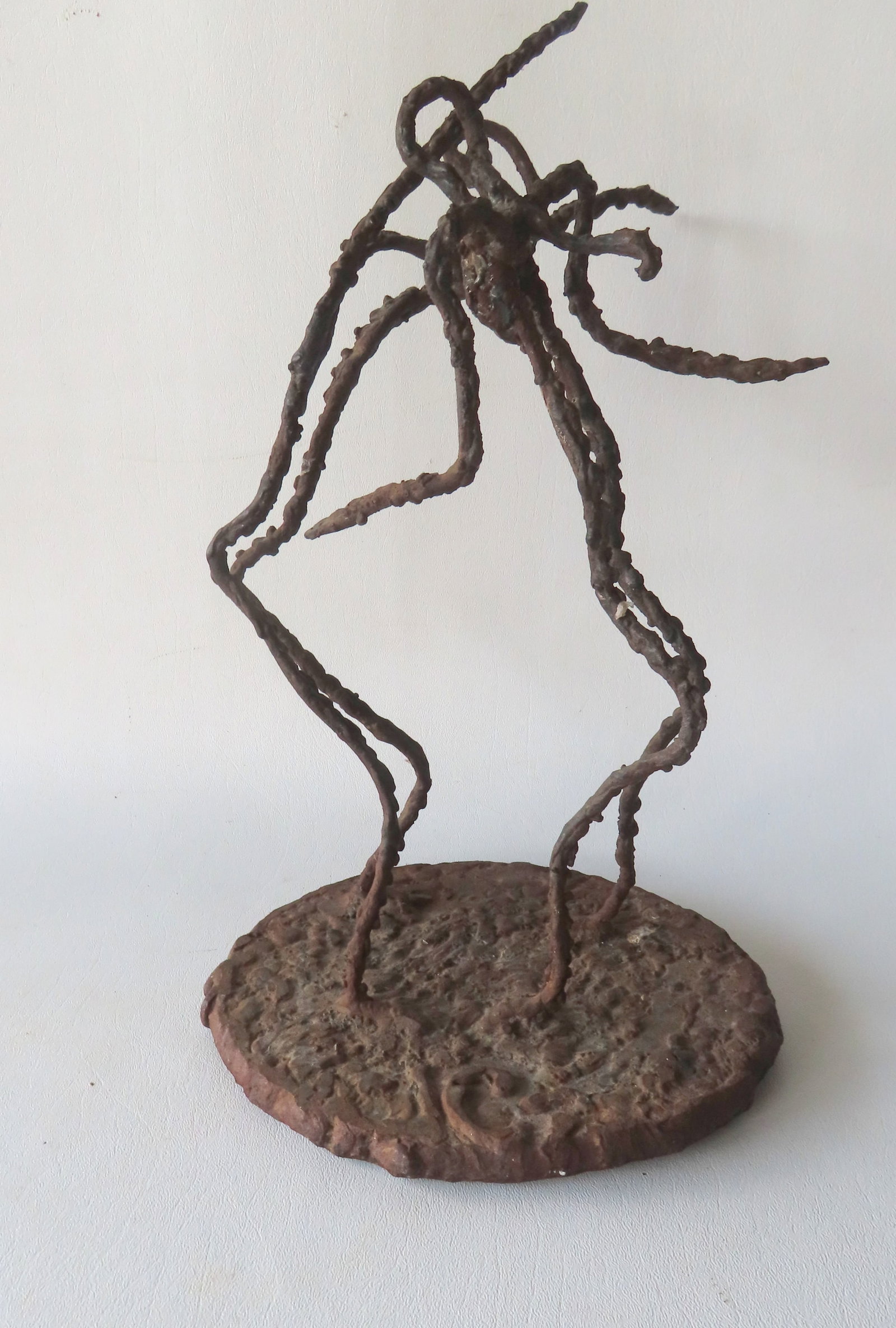 A mid-century modern iron sculpture depicting to stylized dancers, welded to a near circular iron: A mid-century modern iron sculpture depicting to stylized dancers, welded to a near circular iron base. Initialed signature on base, possibly "IC". Very good condition. The figures measure 15"H x 12"W